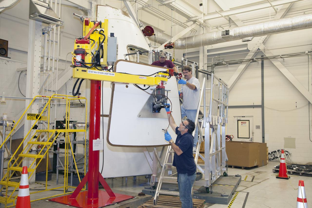 CAPE CANAVERAL, Fla. – Inside the Vehicle Assembly Building at NASA’s Kennedy Space Center in Florida, engineers and technicians are performing a GIZMO demonstration test on the ground test article Launch Abort System, or LAS, ogive panel and an Orion crew module simulator. Technicians practice lining up the GIZMO, a pneumatically-balanced manipulator that will be used for installation of the hatches on the crew module and LAS for the uncrewed Exploration Flight Test-1 and Exploration Mission-1, on the ogive panel mockup hatch. The Ground Systems Development and Operations Program is running the test to demonstrate that the GIZMO can meet the reach and handling requirements for the task.    Orion is the exploration spacecraft designed to carry astronauts to destinations not yet explored by humans, including an asteroid and Mars. It will have emergency abort capability, sustain the crew during space travel and provide safe re-entry from deep space return velocities. The first unpiloted test flight of the Orion is scheduled to launch later this year atop a Delta IV rocket and in 2017 on NASA’s Space Launch System rocket. For more information, visit http://www.nasa.gov/orion. Photo credit: NASA/Daniel Casper
