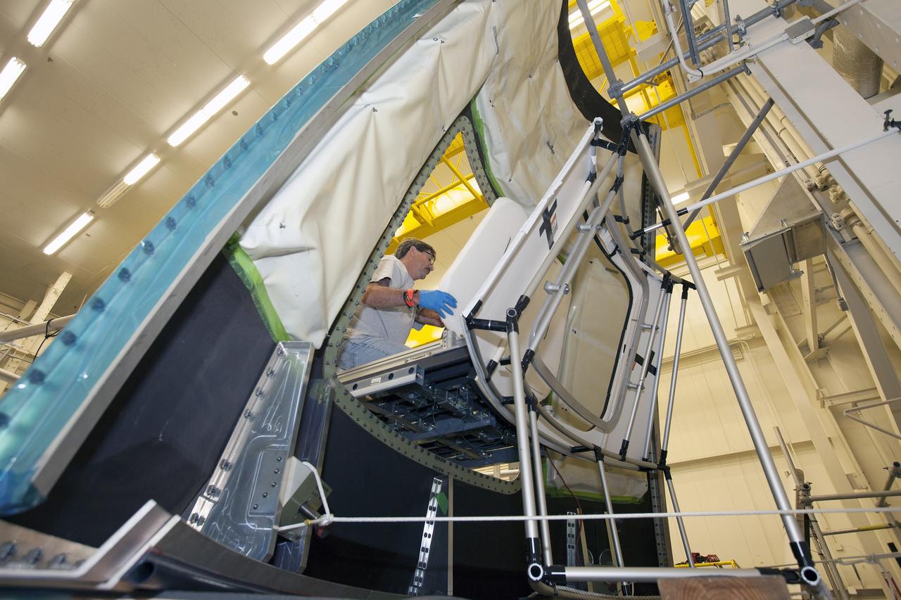 CAPE CANAVERAL, Fla. – Inside the Vehicle Assembly Building at NASA’s Kennedy Space Center in Florida, a GIZMO demonstration test is being performed on the ground test article Launch Abort System, or LAS, ogive panel and an Orion crew module simulator. A technician on an access platform and diving board removes the mockup of the crew module hatch. The GIZMO is a pneumatically-balanced manipulator that will be used for installation of the hatches on the crew module and LAS for the uncrewed Exploration Flight Test-1 and Exploration Mission-1. The Ground Systems Development and Operations Program is running the test to demonstrate that the GIZMO can meet the reach and handling requirements for the task.    Orion is the exploration spacecraft designed to carry astronauts to destinations not yet explored by humans, including an asteroid and Mars. It will have emergency abort capability, sustain the crew during space travel and provide safe re-entry from deep space return velocities. The first unpiloted test flight of the Orion is scheduled to launch later this year atop a Delta IV rocket and in 2017 on NASA’s Space Launch System rocket. For more information, visit http://www.nasa.gov/orion. Photo credit: NASA/Daniel Casper