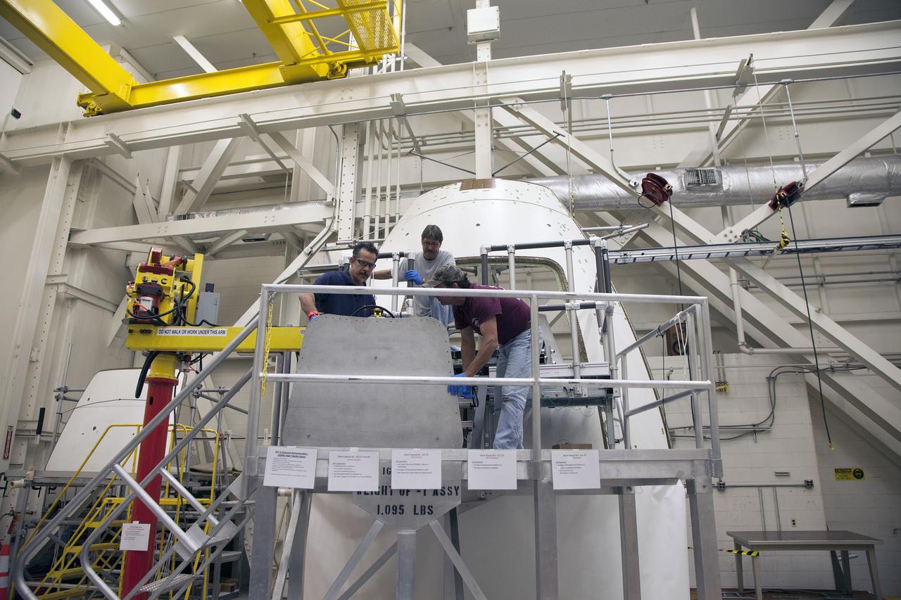 CAPE CANAVERAL, Fla. – Inside the Vehicle Assembly Building at NASA’s Kennedy Space Center in Florida, a GIZMO demonstration test is being performed on the ground test article Launch Abort System, or LAS, ogive panel and an Orion crew module simulator. An access platform has been added leading up to the mockup of the crew module. Technicians are preparing the mockup of the crew module inner hatch for installation using the GIZMO, a pneumatically-balanced manipulator that will be used for the uncrewed Exploration Flight Test-1 and Exploration Mission-1. The Ground Systems Development and Operations Program is running the test to demonstrate that the GIZMO can meet the reach and handling requirements for the task.    Orion is the exploration spacecraft designed to carry astronauts to destinations not yet explored by humans, including an asteroid and Mars. It will have emergency abort capability, sustain the crew during space travel and provide safe re-entry from deep space return velocities. The first unpiloted test flight of the Orion is scheduled to launch later this year atop a Delta IV rocket and in 2017 on NASA’s Space Launch System rocket. For more information, visit http://www.nasa.gov/orion. Photo credit: NASA/Daniel Casper