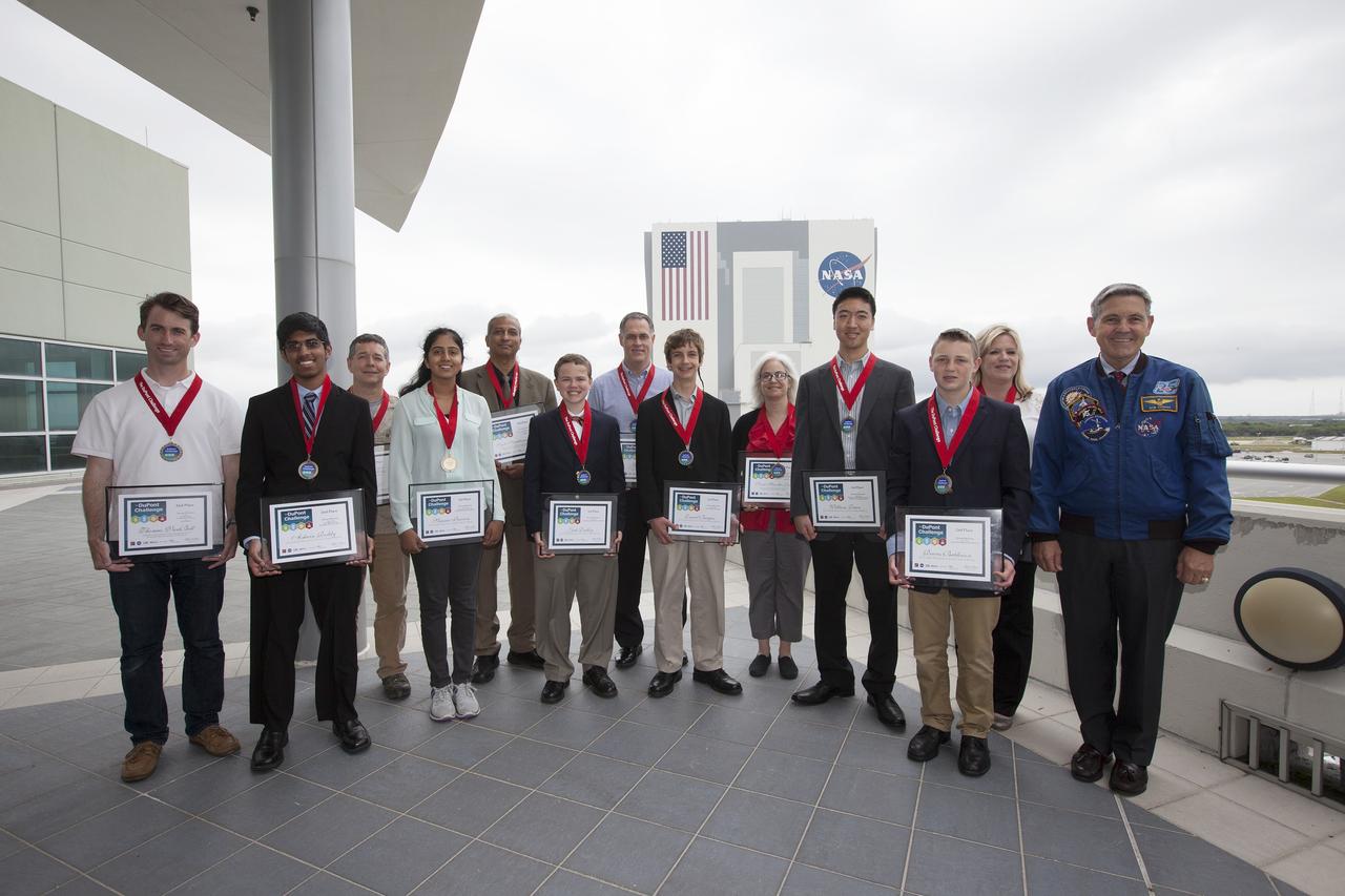 CAPE CANAVERAL, Fla. – The winning students and their teachers of the 2014 DuPont Challenge Science Essay Competition show off their awards after a ceremony at the Operations and Support Building II at Kennedy Space Center in Florida. Center Director Bob Cabana is at right. The challenge, now in its 28th year, reaches out to students from grades seven through 12 from all 50 states and Canada. More than 200,000 students entered the competition. The DuPont Challenge aims to inspire students to excel and achieve in scientific writing and pursue careers in science, technology, engineering and mathematics STEM. The challenge honors space shuttle Challenger's STS-51L crew members who gave their lives while furthering the cause of exploration and discovery. For more information on the challenge, go to http://thechallenge.dupont.com/sponsors/nasa.php. Photo credit: NASA/Kim Shiflett