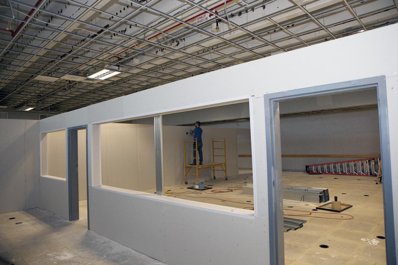 CAPE CANAVERAL, Fla. – A construction worker completes the installation of an inner wall inside Firing Room 4 in the Launch Control Center at NASA's Kennedy Space Center in Florida. The main floor has been divided into four separate rooms. The windows and doors between the rooms have been framed in. The Ground Systems Development and Operations Program is overseeing efforts to create a new firing room based on a multi-user concept.    The design of Firing Room 4 will incorporate five control room areas that are flexible to meet current and future NASA and commercial user requirements. The equipment and most of the consoles from Firing Room 4 were moved to Firing Room 2 for possible future reuse. Photo credit: NASA/Daniel Casper