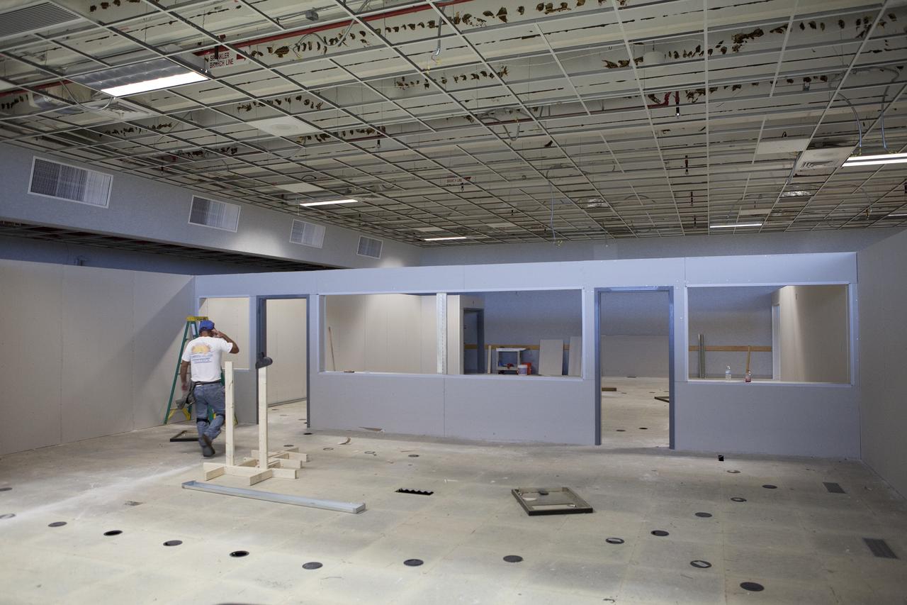 CAPE CANAVERAL, Fla. – A construction worker completes the installation of an inner wall inside Firing Room 4 in the Launch Control Center at NASA's Kennedy Space Center in Florida. The main floor has been divided into four separate rooms. The windows and doors between the rooms have been framed in. Ceiling tiles have been removed for upgrades to conduit and wiring. The Ground Systems Development and Operations Program is overseeing efforts to create a new firing room based on a multi-user concept.    The design of Firing Room 4 will incorporate five control room areas that are flexible to meet current and future NASA and commercial user requirements. The equipment and most of the consoles from Firing Room 4 were moved to Firing Room 2 for possible future reuse. Photo credit: NASA/Daniel Casper