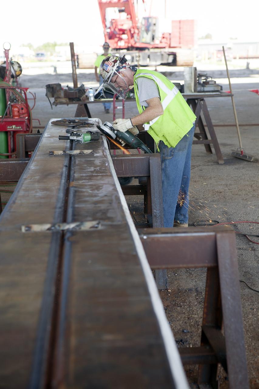 CAPE CANAVERAL, Fla. – Modifications continue on the Mobile Launcher, or ML, at the Mobile Launcher Park Site at NASA’s Kennedy Space Center in Florida. A construction worker trims a section of a steel beam. The ML is being modified and strengthened to accommodate the weight, size and thrust at launch of NASA's Space Launch System, or SLS, and Orion spacecraft.    In 2013, the agency awarded a contract to J.P. Donovan Construction Inc. of Rockledge, Fla., to modify the ML, which is one of the key elements of ground support equipment that is being upgraded by the Ground Systems Development and Operations Program office at Kennedy. The existing 24-foot exhaust hole is being enlarged and strengthened for the larger, heavier SLS rocket. The ML will carry the SLS rocket and Orion spacecraft to Launch Pad 39B for its first mission, Exploration Mission-1, in 2017. Photo credit: NASA/Daniel Casper