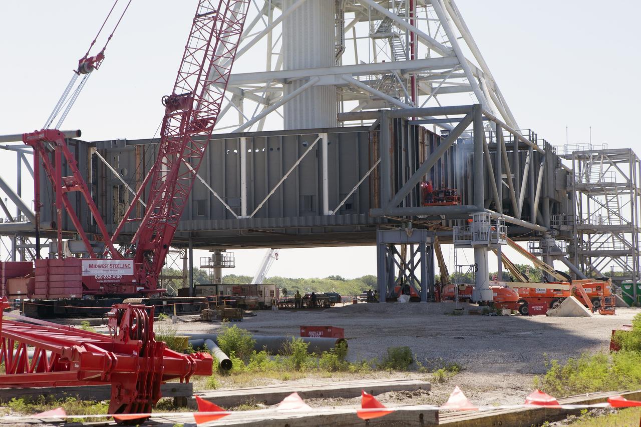 CAPE CANAVERAL, Fla. – Modifications continue on the Mobile Launcher, or ML, at the Mobile Launcher Park Site at NASA’s Kennedy Space Center in Florida. Construction workers on lifts are welding sections of the steel walls. The ML is being modified and strengthened to accommodate the weight, size and thrust at launch of NASA's Space Launch System and Orion spacecraft.    In 2013, the agency awarded a contract to J.P. Donovan Construction Inc. of Rockledge, Fla., to modify the ML, which is one of the key elements of ground support equipment that is being upgraded by the Ground Systems Development and Operations Program office at Kennedy. The existing 24-foot exhaust hole is being enlarged and strengthened for the larger, heavier SLS rocket. The ML will carry the SLS rocket and Orion spacecraft to Launch Pad 39B for its first mission, Exploration Mission-1, in 2017. Photo credit: NASA/Daniel Casper