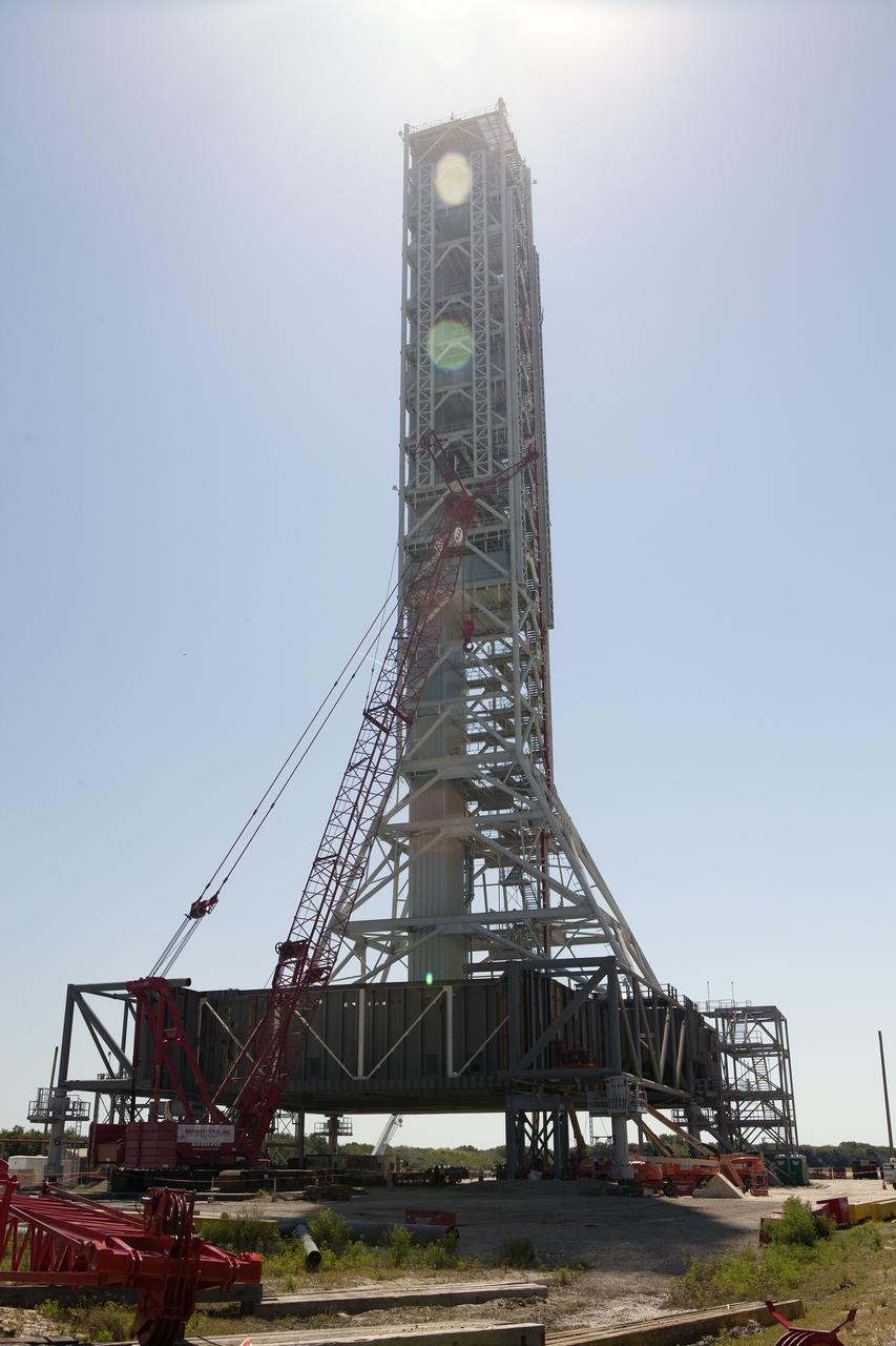CAPE CANAVERAL, Fla. – Modifications continue on the Mobile Launcher, or ML, at the Mobile Launcher Park Site at NASA’s Kennedy Space Center in Florida. A large crane is situated next to the ML for lifting of heavy metal beams and other construction materials.    In 2013, the agency awarded a contract to J.P. Donovan Construction Inc. of Rockledge, Fla., to modify the ML, which is one of the key elements of ground support equipment that is being upgraded by the Ground Systems Development and Operations Program office at Kennedy. The existing 24-foot exhaust hole is being enlarged and strengthened for the larger, heavier SLS rocket. The ML will carry the SLS rocket and Orion spacecraft to Launch Pad 39B for its first mission, Exploration Mission-1, in 2017. Photo credit: NASA/Daniel Casper
