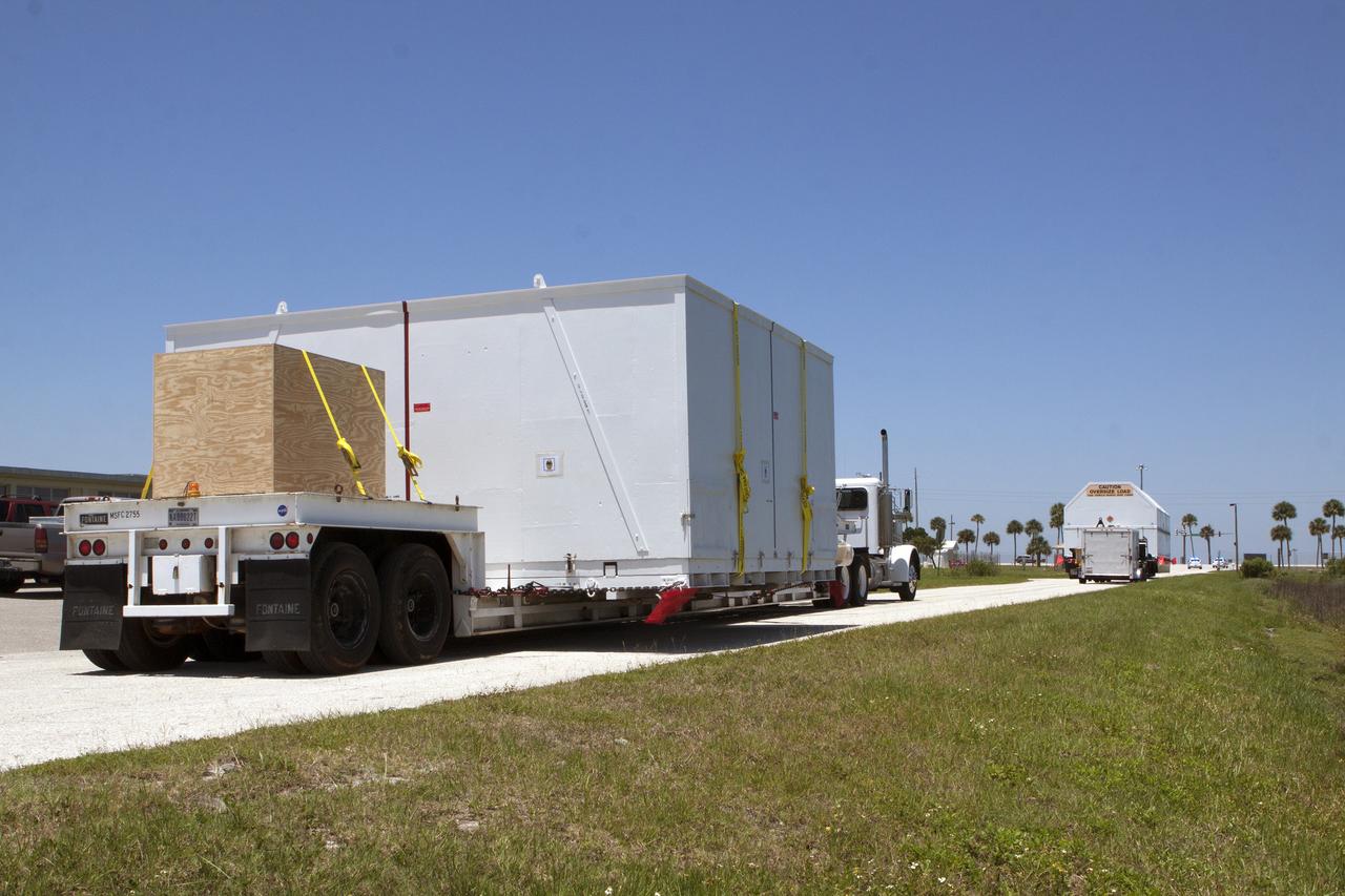 CAPE CANAVERAL, Fla. -- After arriving by barge at the U.S. Army Outpost wharf at Port Canaveral in Florida, the second stage, port booster and spacecraft adapter, the remaining stages for the United Launch Alliance Delta IV Heavy boosters for NASA’s upcoming Exploration Flight Test-1, or EFT-1, mission with the Orion spacecraft, were offloaded in their containers. They are being transported to the Horizontal Integration Facility, or HIF, at Space Launch Complex 37 on Cape Canaveral Air Force Station. At the HIF, all three booster stages will be processed and checked out before being moved to the nearby launch pad and hoisted into position. The spacecraft adapter will connect Orion to the ULA Delta IV, and also will connect Orion to NASA's new rocket, the Space Launch System, on its first mission in 2017. During the EFT-1 mission, Orion will travel farther into space than any human spacecraft has gone in more than 40 years. The data gathered during the flight will influence design decisions, validate existing computer models and innovative new approaches to space systems development, as well as reduce overall mission risks and costs for later Orion flights. Liftoff of Orion on EFT-1 is planned for fall 2014. Photo credit: NASA/Kim Shiflett