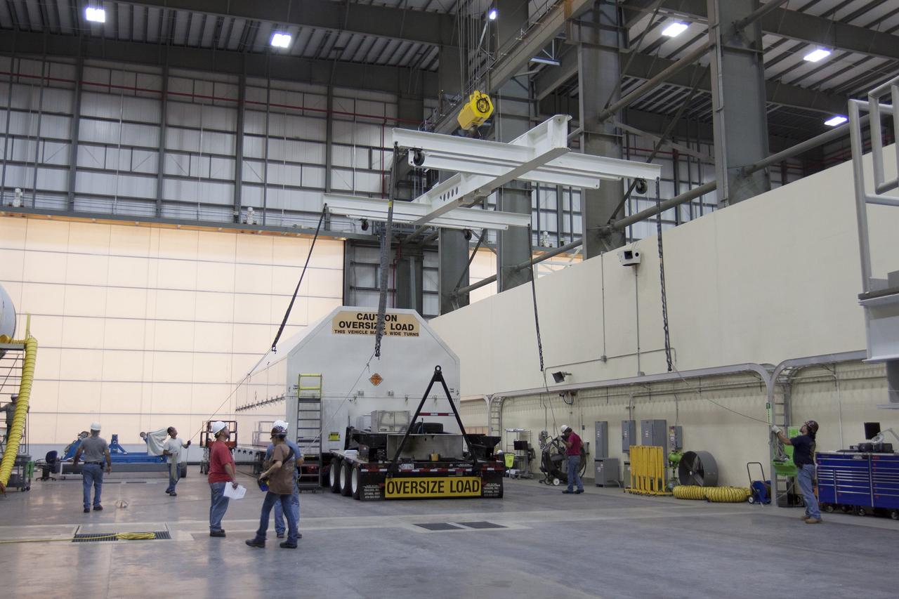 CAPE CANAVERAL, Fla. -- The second stage, port booster and spacecraft adapter, the remaining stages for the United Launch Alliance Delta IV Heavy boosters for NASA’s upcoming Exploration Flight Test-1, or EFT-1, mission with the Orion spacecraft, have been transported in their containers to the Horizontal Integration Facility, or HIF, at Space Launch Complex 37 on Cape Canaveral Air Force Station in Florida for uncrating. The segments arrived by barge at the U.S. Army Outpost wharf at Port Canaveral. At the HIF, all three booster stages will be processed and checked out before being moved to the nearby launch pad and hoisted into position. The spacecraft adapter will connect Orion to the ULA Delta IV, and also will connect Orion to NASA's new rocket, the Space Launch System, on its first mission in 2017. During the EFT-1 mission, Orion will travel farther into space than any human spacecraft has gone in more than 40 years. The data gathered during the flight will influence design decisions, validate existing computer models and innovative new approaches to space systems development, as well as reduce overall mission risks and costs for later Orion flights. Liftoff of Orion on EFT-1 is planned for fall 2014. Photo credit: NASA/Kim Shiflett