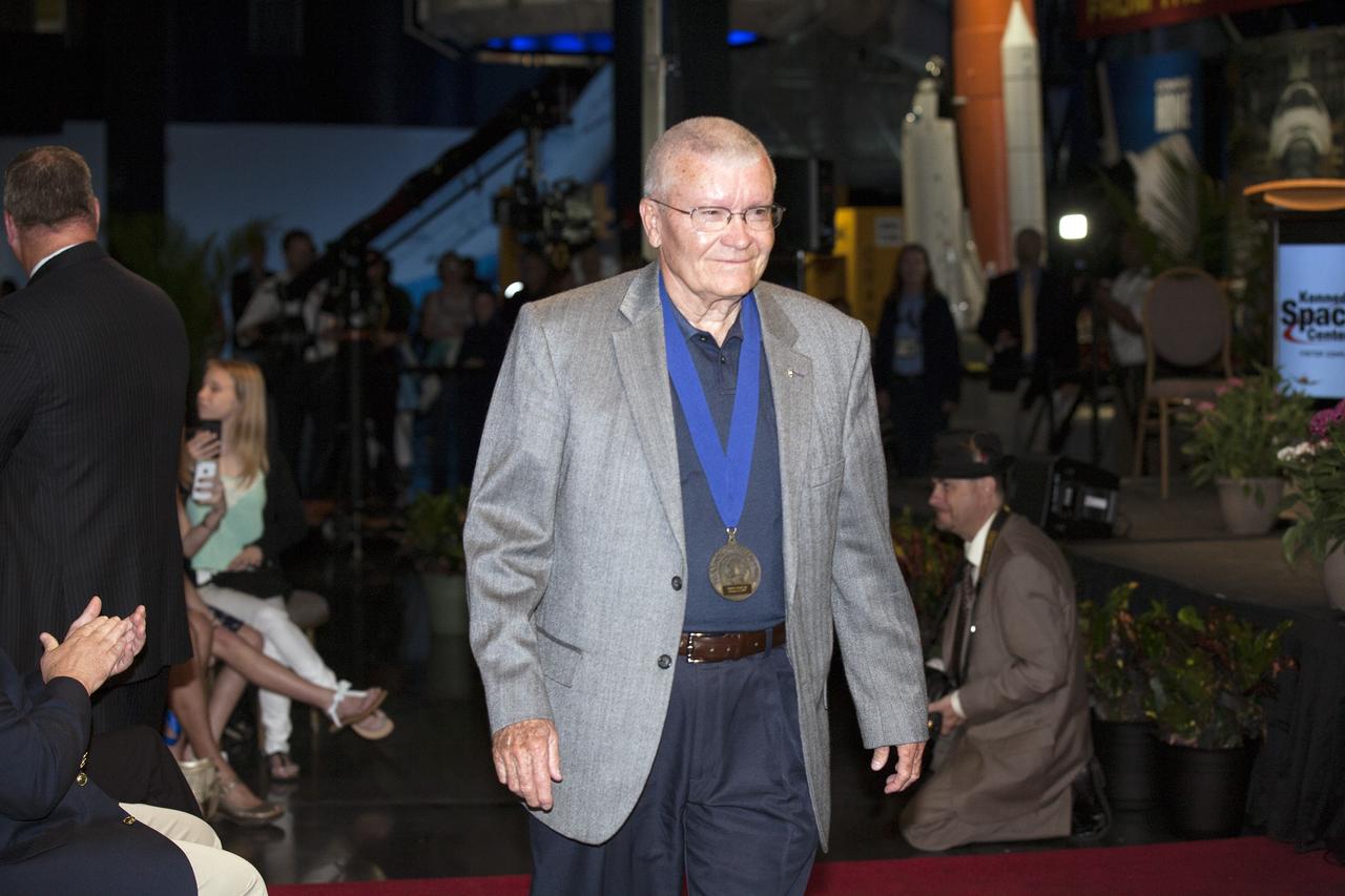 CAPE CANAVERAL, Fla. -- Inside the Space Shuttle Atlantis attraction at NASA’s Kennedy Space Center Visitor Complex in Florida, former NASA astronaut and Hall of Famer Fred Haise walks the red carpet at the 2014 U.S. Astronaut Hall of Fame Induction ceremony. Space shuttle astronauts and space explorers Shannon Lucid and Jerry Ross were inducted into the Hall of Fame Class of 2014.    The 2014 inductees are selected by a committee of Hall of Fame astronauts, former NASA officials, flight directors, historians and journalists. The process is administered by the Astronaut Scholarship Foundation. To be eligible, an astronaut must have made his or her first flight at least 17 years before the induction. Candidates must be a U.S. citizen and a NASA-trained commander, pilot or mission specialist who has orbited the earth at least once. Including Lucid and Ross, 87 astronauts have been inducted into the AHOF.  Photo credit: NASA/Kim Shiflett