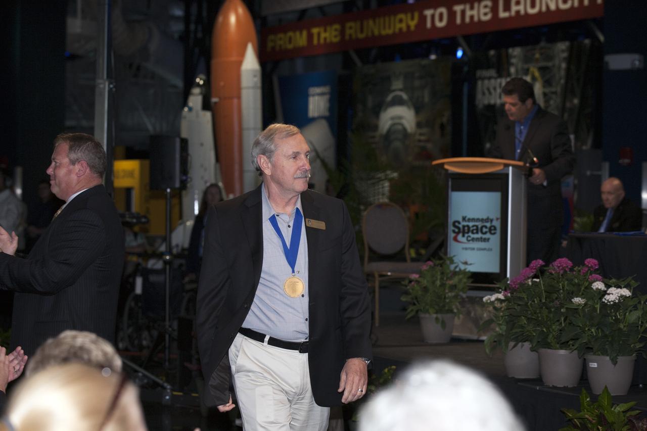 CAPE CANAVERAL, Fla. -- Inside the Space Shuttle Atlantis attraction at NASA’s Kennedy Space Center Visitor Complex in Florida, former NASA astronaut and Hall of Famer Curt Brown walks the red carpet at the 2014 U.S. Astronaut Hall of Fame Induction ceremony. Space shuttle astronauts and space explorers Shannon Lucid and Jerry Ross were inducted into the Hall of Fame Class of 2014.    The 2014 inductees are selected by a committee of Hall of Fame astronauts, former NASA officials, flight directors, historians and journalists. The process is administered by the Astronaut Scholarship Foundation. To be eligible, an astronaut must have made his or her first flight at least 17 years before the induction. Candidates must be a U.S. citizen and a NASA-trained commander, pilot or mission specialist who has orbited the earth at least once. Including Lucid and Ross, 87 astronauts have been inducted into the AHOF.  Photo credit: NASA/Kim Shiflett