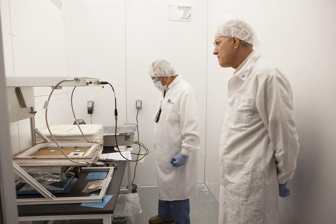 CAPE CANAVERAL, Fla. – Researchers prepare to activate the Veggie plant growth system inside a control chamber at the Space Station Processing Facility at NASA's Kennedy Space Center in Florida. From left, are George Guerra, quality control engineer, and Chuck Spern, lead project engineer, both with QinetiQ North America on the Engineering Services Contract. The growth chamber will be used as a control unit and procedures will be followed identical to those being performed on Veggie and the Veg-01 experiment on the International Space Station by Expedition 39 flight engineer and NASA astronaut Steve Swanson.    Veggie and Veg-01 were delivered to the space station aboard the SpaceX-3 mission. Veggie is the first fresh food production system delivered to the station. Six plant pillows, each containing outredgeous red romaine lettuce seeds and a root mat were inserted into Veggie. The plant chamber's red, blue and green LED lights were activated. The plant growth will be monitored for 28 days. At the end of the cycle, the plants will be carefully harvested, frozen and stored for return to Earth. Photo credit: NASA/Dimitri Gerondidakis