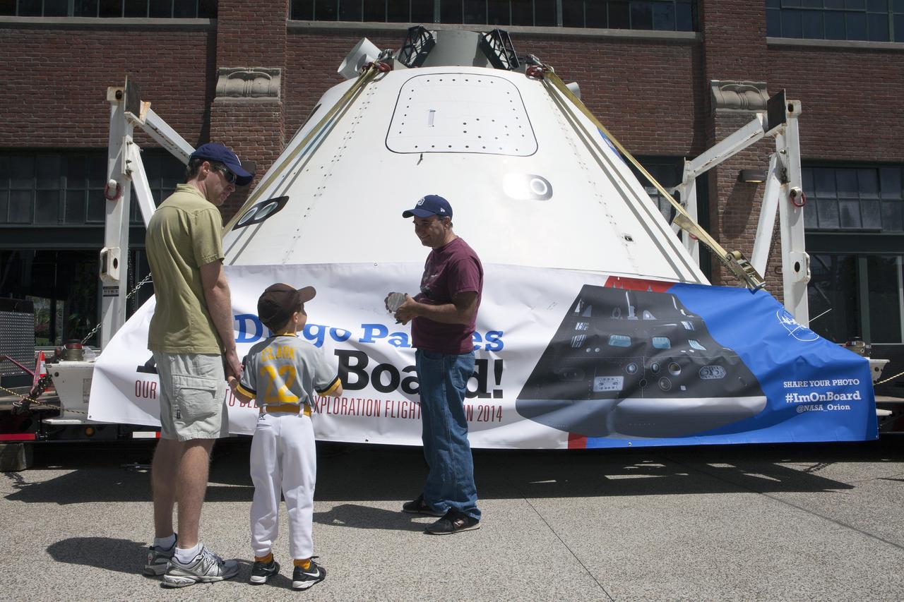 CAPE CANAVERAL, Fla. – San Diego Padres fans talk to Doug Lenhardt, Kennedy Space Center's Exploration Flight Test-1, or EFT-1, mission integration manager outside Petco Field in San Diego, California. NASA's Orion boilerplate test vehicle is on display. The boilerplate test vehicle is being prepared for an Exploration Flight Test-1, or EFT-1, pre-transportation test. The Ground Systems Development and Operations Program will run the test at the U.S. Naval Base San Diego to simulate retrieval and transportation procedures for Orion after it splashes down in the ocean and is retrieved for return to land and ground transportation back to Kennedy Space Center in Florida.     Orion is the exploration spacecraft designed to carry astronauts to destinations not yet explored by humans, including an asteroid and Mars. It will have emergency abort capability, sustain the crew during space travel and provide safe re-entry from deep space return velocities. The first unpiloted test flight of the Orion is scheduled to launch later this year atop a Delta IV rocket and in 2017 on NASA’s Space Launch System rocket. For more information, visit http://www.nasa.gov/orion. Photo credit: NASA/Kim Shiflett