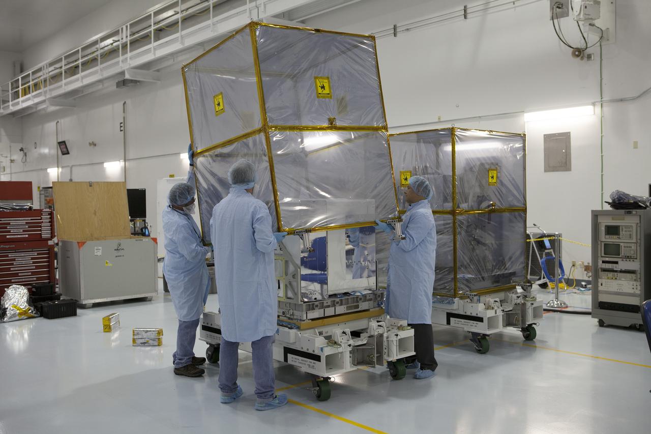 CAPE CANAVERAL, Fla. – Payload technicians and Jet Propulsion Laboratory personnel carefully remove the shipping cover from one of the components of NASA's International Space Station-RapidScat scatterometer instrument inside Kennedy Space Center's Space Station Processing Facility. ISS-RapidScat is the first scientific Earth-observing instrument designed to operate from the exterior of the space station. It will measure Earth's ocean surface wind speed and direction, providing data to be used in weather and marine forecasting. Built at NASA's Jet Propulsion Laboratory, ISS-RapidScat is slated to fly on the SpaceX-4 commercial cargo resupply flight in 2014. For more information, visit http://www.jpl.nasa.gov/missions/iss-rapidscat. Photo credit: NASA/Dimitri Gerondidakis