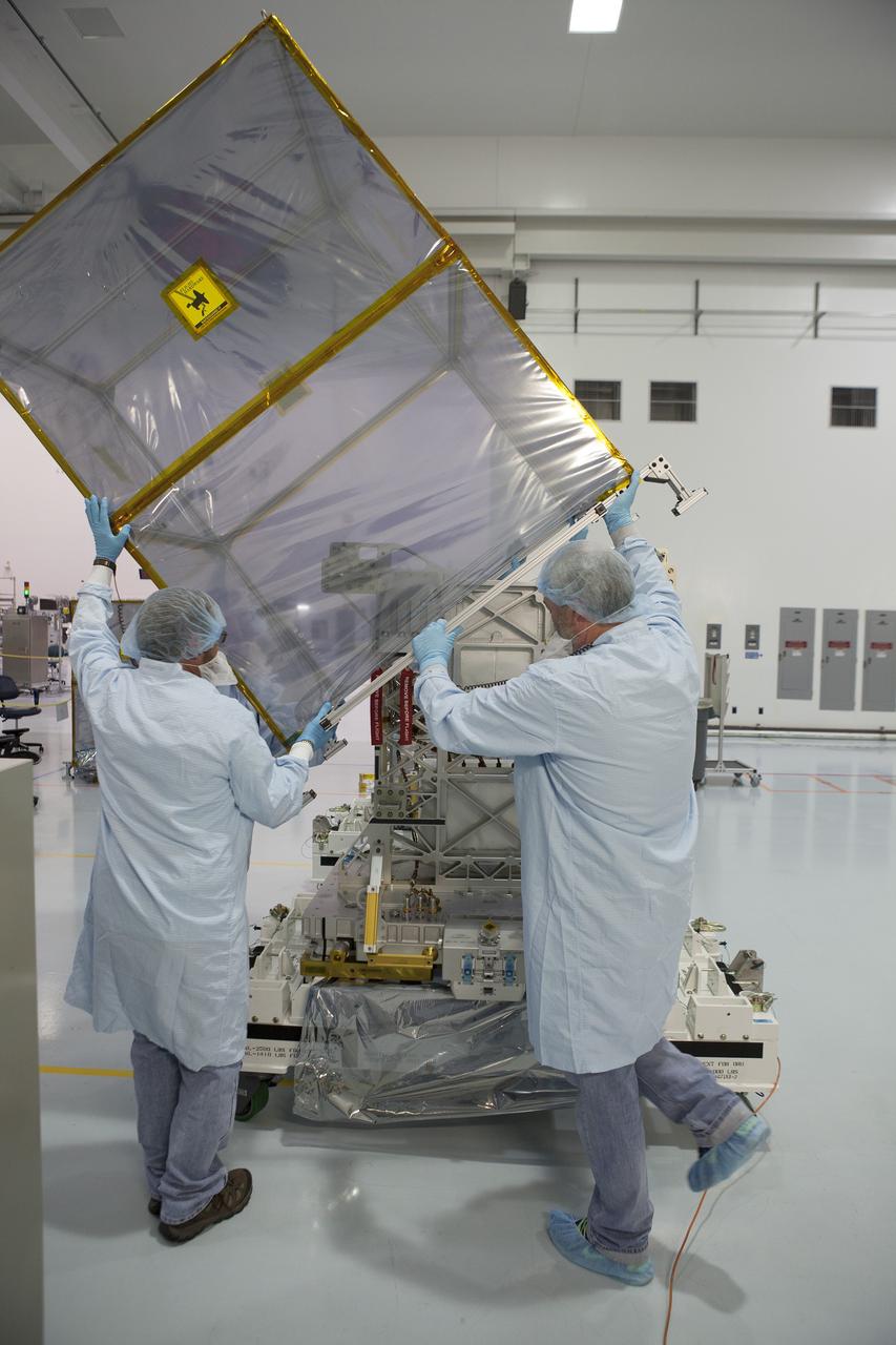 CAPE CANAVERAL, Fla. – Payload technicians and Jet Propulsion Laboratory personnel carefully remove the shipping cover from one of the components of NASA's International Space Station-RapidScat scatterometer instrument inside Kennedy Space Center's Space Station Processing Facility. ISS-RapidScat is the first scientific Earth-observing instrument designed to operate from the exterior of the space station. It will measure Earth's ocean surface wind speed and direction, providing data to be used in weather and marine forecasting. Built at NASA's Jet Propulsion Laboratory, ISS-RapidScat is slated to fly on the SpaceX-4 commercial cargo resupply flight in 2014. For more information, visit http://www.jpl.nasa.gov/missions/iss-rapidscat. Photo credit: NASA/Dimitri Gerondidakis