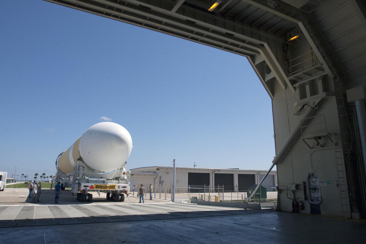 CAPE CANAVERAL, Fla. -- The port booster for the United Launch Alliance Delta IV Heavy for Exploration Flight Test-1, or EFT-1, has been offloaded from the barge at the U.S. Army Outpost wharf at Port Canaveral in Florida and will be transported to the Horizontal Integration Facility, or HIF, at Space Launch Complex 37 on Cape Canaveral Air Force Station. The upper stage and spacecraft adapter arrived with the booster and were transported to the HIF on May 6.    At the HIF, all three booster stages will be processed and checked out before being moved to the nearby launch pad and hoisted into position. The spacecraft adapter will connect Orion to the ULA Delta IV, and also will connect Orion to NASA's new rocket, the Space Launch System, on its first mission in 2017. During the EFT-1 mission, Orion will travel farther into space than any human spacecraft has gone in more than 40 years. The data gathered during the flight will influence design decisions, validate existing computer models and innovative new approaches to space systems development, as well as reduce overall mission risks and costs for later Orion flights. Liftoff of Orion on EFT-1 is planned for fall 2014. Photo credit: NASA/Kim Shiflett