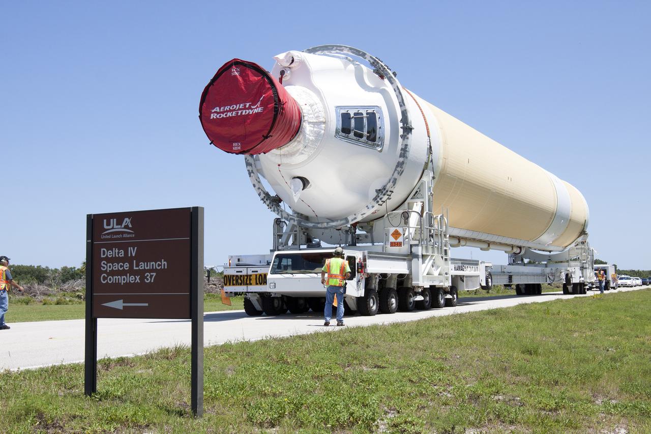 CAPE CANAVERAL, Fla. -- A transporter for oversize loads carries the port booster for the United Launch Alliance Delta IV Heavy for Exploration Flight Test-1, or EFT-1, to Space Launch Complex 37 on Cape Canaveral Air Force Station after it was offloaded from the barge at the U.S. Army Outpost wharf at Port Canaveral in Florida. The booster will be transported to the Horizontal Integration Facility, or HIF, at the launch complex. The upper stage and spacecraft adapter arrived with the booster and were transported to the HIF on May 6.    At the HIF, all three booster stages will be processed and checked out before being moved to the nearby launch pad and hoisted into position. The spacecraft adapter will connect Orion to the ULA Delta IV, and also will connect Orion to NASA's new rocket, the Space Launch System, on its first mission in 2017. During the EFT-1 mission, Orion will travel farther into space than any human spacecraft has gone in more than 40 years. The data gathered during the flight will influence design decisions, validate existing computer models and innovative new approaches to space systems development, as well as reduce overall mission risks and costs for later Orion flights. Liftoff of Orion on EFT-1 is planned for fall 2014. Photo credit: NASA/Kim Shiflett