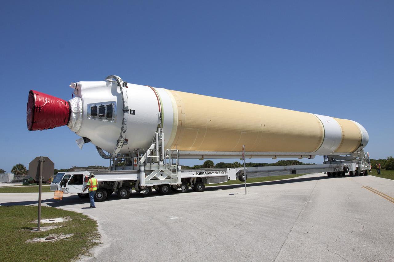 CAPE CANAVERAL, Fla. -- A transporter for oversize loads carries the port booster for the United Launch Alliance Delta IV Heavy for Exploration Flight Test-1, or EFT-1, to Space Launch Complex 37 on Cape Canaveral Air Force Station after it was offloaded from the barge at the U.S. Army Outpost wharf at Port Canaveral in Florida. The booster will be transported to the Horizontal Integration Facility, or HIF, at the launch complex. The upper stage and spacecraft adapter arrived with the booster and were transported to the HIF on May 6.    At the HIF, all three booster stages will be processed and checked out before being moved to the nearby launch pad and hoisted into position. The spacecraft adapter will connect Orion to the ULA Delta IV, and also will connect Orion to NASA's new rocket, the Space Launch System, on its first mission in 2017. During the EFT-1 mission, Orion will travel farther into space than any human spacecraft has gone in more than 40 years. The data gathered during the flight will influence design decisions, validate existing computer models and innovative new approaches to space systems development, as well as reduce overall mission risks and costs for later Orion flights. Liftoff of Orion on EFT-1 is planned for fall 2014. Photo credit: NASA/Kim Shiflett