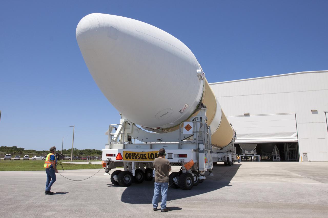CAPE CANAVERAL, Fla. -- A transporter for oversize loads carries the port booster for the United Launch Alliance Delta IV Heavy for Exploration Flight Test-1, or EFT-1, to the Horizontal Integration Facility, or HIF, at Space Launch Complex 37 on Cape Canaveral Air Force Station in Florida. The upper stage and spacecraft adapter arrived with the booster on a barge at the U.S. Army Outpost wharf at Port Canaveral, and were transported to the HIF on May 6.    At the HIF, all three booster stages will be processed and checked out before being moved to the nearby launch pad and hoisted into position. The spacecraft adapter will connect Orion to the ULA Delta IV, and also will connect Orion to NASA's new rocket, the Space Launch System, on its first mission in 2017. During the EFT-1 mission, Orion will travel farther into space than any human spacecraft has gone in more than 40 years. The data gathered during the flight will influence design decisions, validate existing computer models and innovative new approaches to space systems development, as well as reduce overall mission risks and costs for later Orion flights. Liftoff of Orion on EFT-1 is planned for fall 2014. Photo credit: NASA/Kim Shiflett