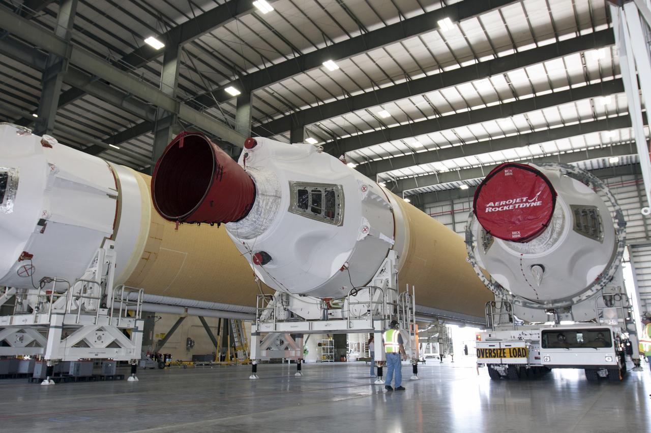 CAPE CANAVERAL, Fla. -- A transporter for oversize loads carries the port booster for the United Launch Alliance Delta IV Heavy for Exploration Flight Test-1, or EFT-1, into the Horizontal Integration Facility, or HIF, at Space Launch Complex 37 on Cape Canaveral Air Force Station in Florida. The port booster joins the other two boosters of the Delta IV Heavy already in the HIF. The upper stage and spacecraft adapter arrived with the booster on a barge at the U.S. Army Outpost wharf at Port Canaveral, and were transported to the HIF on May 6.    At the HIF, all three booster stages will be processed and checked out before being moved to the nearby launch pad and hoisted into position. The spacecraft adapter will connect Orion to the ULA Delta IV, and also will connect Orion to NASA's new rocket, the Space Launch System, on its first mission in 2017. During the EFT-1 mission, Orion will travel farther into space than any human spacecraft has gone in more than 40 years. The data gathered during the flight will influence design decisions, validate existing computer models and innovative new approaches to space systems development, as well as reduce overall mission risks and costs for later Orion flights. Liftoff of Orion on EFT-1 is planned for fall 2014. Photo credit: NASA/Kim Shiflett