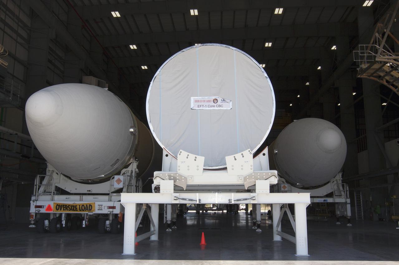 CAPE CANAVERAL, Fla. -- A transporter for oversize loads carries the port booster for the United Launch Alliance Delta IV Heavy for Exploration Flight Test-1, or EFT-1, into the Horizontal Integration Facility, or HIF, at Space Launch Complex 37 on Cape Canaveral Air Force Station in Florida. The port booster joins the other two boosters of the Delta IV Heavy already in the HIF. The upper stage and spacecraft adapter arrived with the booster on a barge at the U.S. Army Outpost wharf at Port Canaveral, and were transported to the HIF on May 6.    At the HIF, all three booster stages will be processed and checked out before being moved to the nearby launch pad and hoisted into position. The spacecraft adapter will connect Orion to the ULA Delta IV, and also will connect Orion to NASA's new rocket, the Space Launch System, on its first mission in 2017. During the EFT-1 mission, Orion will travel farther into space than any human spacecraft has gone in more than 40 years. The data gathered during the flight will influence design decisions, validate existing computer models and innovative new approaches to space systems development, as well as reduce overall mission risks and costs for later Orion flights. Liftoff of Orion on EFT-1 is planned for fall 2014. Photo credit: NASA/Kim Shiflett