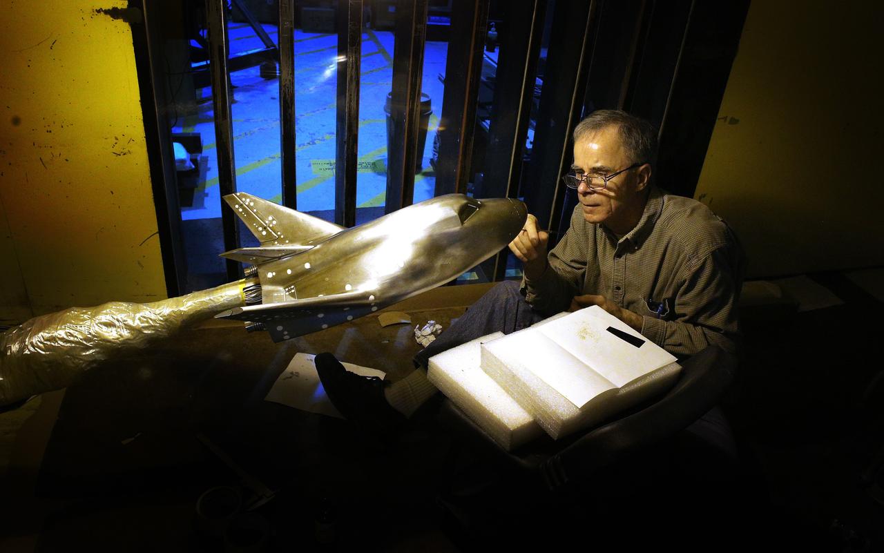 HAMPTON, Va. – NASA technician Ricky Hall works inside the Unitary Plan Wind Tunnel at NASA's Langley Research Center in Virginia to affix grains of sand to a precise scale model of the Dream Chaser spacecraft. Sierra Nevada Corporation is developing the Dream Chaser in partnership with NASA's Commercial Crew Program. The sand creates turbulence at key points to simulate the conditions the real spacecraft will encounter during its return to Earth. The data gathered from the wind tunnel was used to further test the design through the company's Commercial Crew Integrated Capability agreement with NASA. Photo credit: NASA/ David C. Bowman