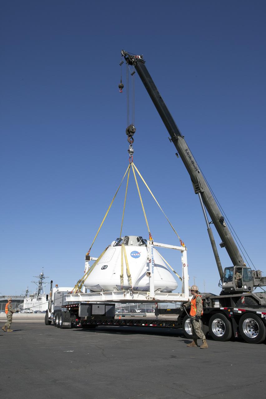 SAN DIEGO, Calif. – A crane lifts the Orion boilerplate test vehicle from a flatbed truck to lower it to the ground at a warehouse at the Naval Base San Diego in California. The test vehicle is attached to the BTA handling fixture. The Ground Systems Development and Operations Program, Lockheed Martin and the U.S. Navy are evaluating the hardware and processes for preparing the Orion crew module for Exploration Flight Test-1, or EFT-1, for overland transport from the naval base to NASA's Kennedy Space Center in Florida. Orion is the exploration spacecraft designed to carry astronauts to destinations not yet explored by humans, including an asteroid and Mars. It will have emergency abort capability, sustain the crew during space travel and provide safe re-entry from deep space return velocities. The first unpiloted test flight of the Orion is scheduled to launch later this year atop a Delta IV rocket from Cape Canaveral Air Force Station in Florida to an altitude of 3,600 miles above the Earth's surface. The two-orbit, four-hour flight test will help engineers evaluate the systems critical to crew safety including the heat shield, parachute system and launch abort system. For more information, visit http://www.nasa.gov/orion. Photo credit: NASA/Kim Shiflett