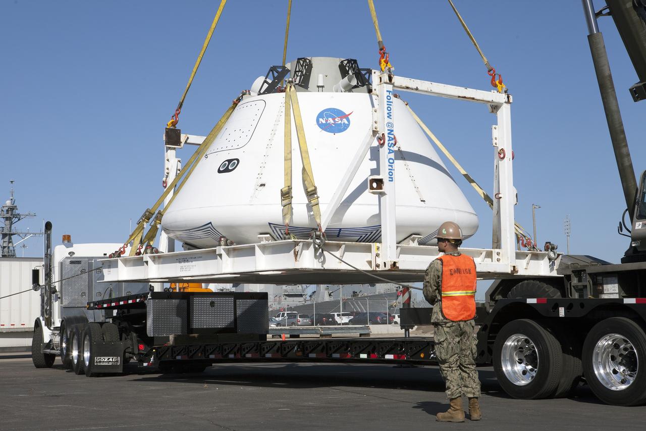SAN DIEGO, Calif. – A crane lifts the Orion boilerplate test vehicle from a flatbed truck to lower it to the ground at a warehouse at the Naval Base San Diego in California. The test vehicle is attached to the BTA handling fixture. The Ground Systems Development and Operations Program, Lockheed Martin and the U.S. Navy are evaluating the hardware and processes for preparing the Orion crew module for Exploration Flight Test-1, or EFT-1, for overland transport from the naval base to NASA's Kennedy Space Center in Florida. Orion is the exploration spacecraft designed to carry astronauts to destinations not yet explored by humans, including an asteroid and Mars. It will have emergency abort capability, sustain the crew during space travel and provide safe re-entry from deep space return velocities. The first unpiloted test flight of the Orion is scheduled to launch later this year atop a Delta IV rocket from Cape Canaveral Air Force Station in Florida to an altitude of 3,600 miles above the Earth's surface. The two-orbit, four-hour flight test will help engineers evaluate the systems critical to crew safety including the heat shield, parachute system and launch abort system. For more information, visit http://www.nasa.gov/orion. Photo credit: NASA/Kim Shiflett
