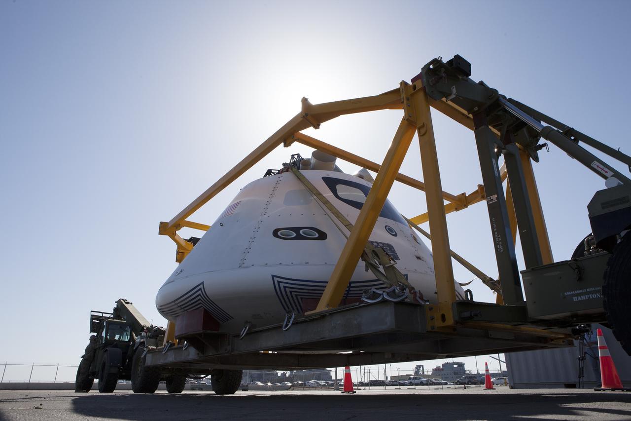 SAN DIEGO, Calif. – The Orion boilerplate test vehicle has been secured in the crew module recovery cradle and raised up at a warehouse at the Naval Base San Diego in California. The Ground Systems Development and Operations Program, Lockheed Martin and U.S. Navy are evaluating the hardware and processes for preparing the Orion crew module for Exploration Flight Test-1, or EFT-1, for overland transport from the naval base to NASA's Kennedy Space Center in Florida.    Orion is the exploration spacecraft designed to carry astronauts to destinations not yet explored by humans, including an asteroid and Mars. It will have emergency abort capability, sustain the crew during space travel and provide safe re-entry from deep space return velocities. The first unpiloted test flight of the Orion is scheduled to launch later this year atop a Delta IV rocket from Cape Canaveral Air Force Station in Florida to an altitude of 3,600 miles above the Earth's surface. The two-orbit, four-hour flight test will help engineers evaluate the systems critical to crew safety including the heat shield, parachute system and launch abort system. For more information, visit http://www.nasa.gov/orion. Photo credit: NASA/Kim Shiflett