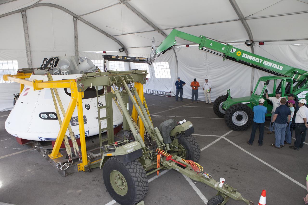 SAN DIEGO, Calif. – The Orion boilerplate test vehicle has been moved into a protective structure at the Mole Pier at the Naval Base San Diego in California for a simulated fit check of the hatch cover. The test vehicle is attached to the crew module recovery cradle. The Ground Systems Development and Operations Program, Lockheed Martin and the U.S. Navy are evaluating the hardware and processes for preparing the Orion crew module for Exploration Flight Test-1, or EFT-1, for overland transport from the naval base to NASA's Kennedy Space Center in Florida.    Orion is the exploration spacecraft designed to carry astronauts to destinations not yet explored by humans, including an asteroid and Mars. It will have emergency abort capability, sustain the crew during space travel and provide safe re-entry from deep space return velocities. The first unpiloted test flight of the Orion is scheduled to launch later this year atop a Delta IV rocket from Cape Canaveral Air Force Station in Florida to an altitude of 3,600 miles above the Earth's surface. The two-orbit, four-hour flight test will help engineers evaluate the systems critical to crew safety including the heat shield, parachute system and launch abort system. For more information, visit http://www.nasa.gov/orion. Photo credit: NASA/Kim Shiflett
