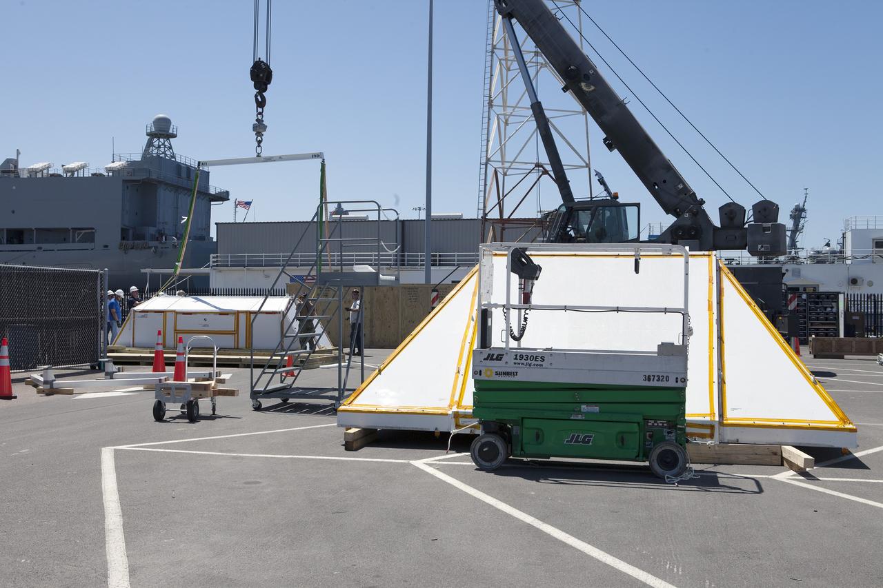SAN DIEGO, Calif. – Workers prepare the crew module transportation fixture for the Orion boilerplate test vehicle at the Mole Pier at the Naval Base San Diego in California. The test vehicle will be moved from the pier to a warehouse at the naval base. The Ground Systems Development and Operations Program, Lockheed Martin and the U.S. Navy are evaluating the hardware and processes for preparing the Orion crew module for Exploration Flight Test-1, or EFT-1, for overland transport from the naval base to NASA's Kennedy Space Center in Florida.    Orion is the exploration spacecraft designed to carry astronauts to destinations not yet explored by humans, including an asteroid and Mars. It will have emergency abort capability, sustain the crew during space travel and provide safe re-entry from deep space return velocities. The first unpiloted test flight of the Orion is scheduled to launch later this year atop a Delta IV rocket from Cape Canaveral Air Force Station in Florida to an altitude of 3,600 miles above the Earth's surface. The two-orbit, four-hour flight test will help engineers evaluate the systems critical to crew safety including the heat shield, parachute system and launch abort system. For more information, visit http://www.nasa.gov/orion. Photo credit: NASA/Kim Shiflett