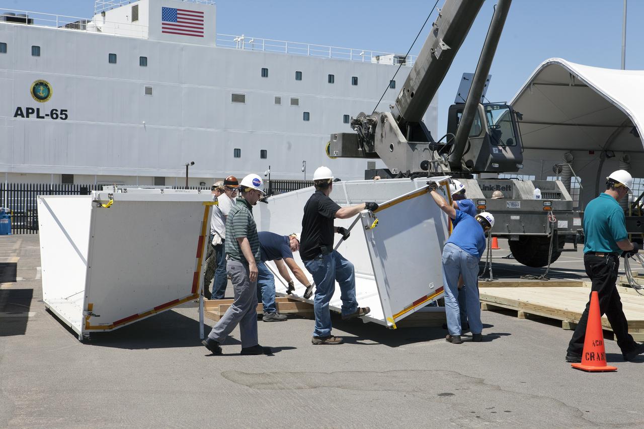 SAN DIEGO, Calif. – Workers prepare to assemble the crew module transportation fixture for the Orion boilerplate test vehicle at the Mole Pier at Naval Base San Diego in California. The test vehicle will be moved from the pier to a warehouse at the naval base. The Ground Systems Development and Operations Program, Lockheed Martin and the U.S. Navy are evaluating the hardware and processes for preparing the Orion crew module for Exploration Flight Test-1, or EFT-1, for overland transport from the naval base to NASA's Kennedy Space Center in Florida. Orion is the exploration spacecraft designed to carry astronauts to destinations not yet explored by humans, including an asteroid and Mars. It will have emergency abort capability, sustain the crew during space travel and provide safe re-entry from deep space return velocities. The first unpiloted test flight of the Orion is scheduled to launch later this year atop a Delta IV rocket from Cape Canaveral Air Force Station in Florida to an altitude of 3,600 miles above the Earth's surface. The two-orbit, four-hour flight test will help engineers evaluate the systems critical to crew safety including the heat shield, parachute system and launch abort system. For more information, visit http://www.nasa.gov/orion. Photo credit: NASA/Kim Shiflett