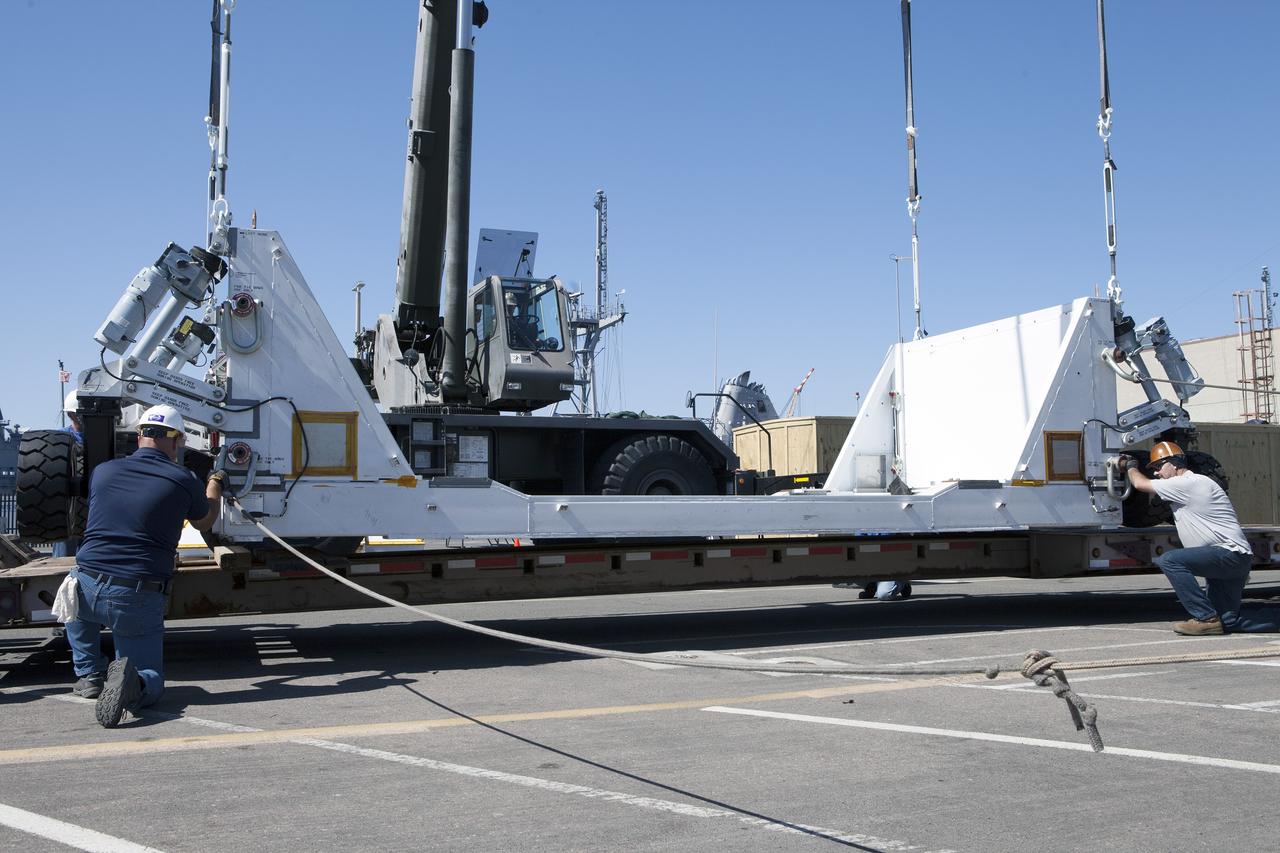 SAN DIEGO, Calif. – Workers prepare the base of the crew module transportation fixture for the Orion boilerplate test vehicle at the Mole Pier at Naval Base San Diego in California. The test vehicle will be moved from the pier to a warehouse hangar at the naval base. The Ground Systems Development and Operations Program, Lockheed Martin and the U.S. Navy are evaluating the hardware and processes for preparing the Orion crew module for Exploration Flight Test-1, or EFT-1, for overland transport from the naval base to NASA's Kennedy Space Center in Florida. Orion is the exploration spacecraft designed to carry astronauts to destinations not yet explored by humans, including an asteroid and Mars. It will have emergency abort capability, sustain the crew during space travel and provide safe re-entry from deep space return velocities. The first unpiloted test flight of the Orion is scheduled to launch later this year atop a Delta IV rocket from Cape Canaveral Air Force Station in Florida to an altitude of 3,600 miles above the Earth's surface. The two-orbit, four-hour flight test will help engineers evaluate the systems critical to crew safety including the heat shield, parachute system and launch abort system. For more information, visit http://www.nasa.gov/orion. Photo credit: NASA/Kim Shiflett