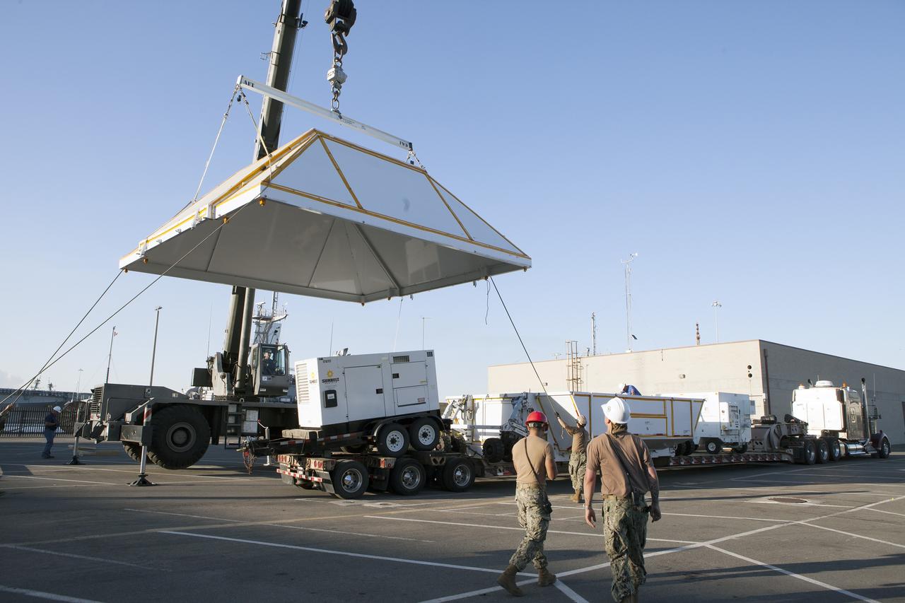 SAN DIEGO, Calif. – Workers prepare the lid for the crew module transportation fixture for the Orion boilerplate test vehicle at the Mole Pier at Naval Base San Diego in California. The Ground Systems Development and Operations Program, Lockheed Martin and the U.S. Navy are evaluating the hardware and processes for preparing the Orion crew module for Exploration Flight Test-1, or EFT-1, for overland transport from the naval base to NASA's Kennedy Space Center in Florida.    Orion is the exploration spacecraft designed to carry astronauts to destinations not yet explored by humans, including an asteroid and Mars. It will have emergency abort capability, sustain the crew during space travel and provide safe re-entry from deep space return velocities. The first unpiloted test flight of the Orion is scheduled to launch later this year atop a Delta IV rocket from Cape Canaveral Air Force Station in Florida to an altitude of 3,600 miles above the Earth's surface. The two-orbit, four-hour flight test will help engineers evaluate the systems critical to crew safety including the heat shield, parachute system and launch abort system. For more information, visit http://www.nasa.gov/orion. Photo credit: NASA/Kim Shiflett