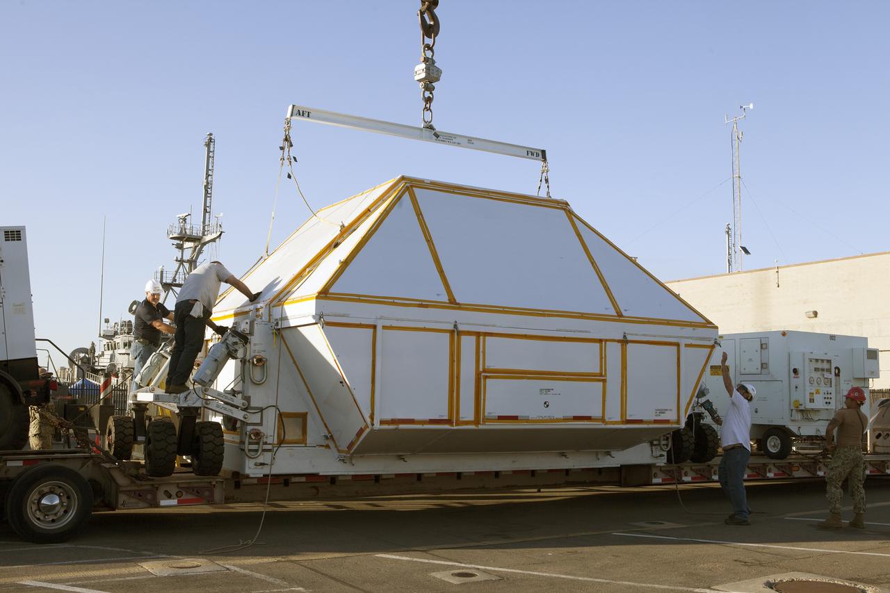 SAN DIEGO, Calif. – Workers simulate securing the crew module transportation fixture around the Orion boilerplate test vehicle at the Mole Pier at Naval Base San Diego in California. The Ground Systems Development and Operations Program, Lockheed Martin and the U.S. Navy are evaluating the hardware and processes for preparing the Orion crew module for Exploration Flight Test-1, or EFT-1, for overland transport from the naval base to NASA's Kennedy Space Center in Florida.    Orion is the exploration spacecraft designed to carry astronauts to destinations not yet explored by humans, including an asteroid and Mars. It will have emergency abort capability, sustain the crew during space travel and provide safe re-entry from deep space return velocities. The first unpiloted test flight of the Orion is scheduled to launch later this year atop a Delta IV rocket from Cape Canaveral Air Force Station in Florida to an altitude of 3,600 miles above the Earth's surface. The two-orbit, four-hour flight test will help engineers evaluate the systems critical to crew safety including the heat shield, parachute system and launch abort system. For more information, visit http://www.nasa.gov/orion. Photo credit: NASA/Kim Shiflett