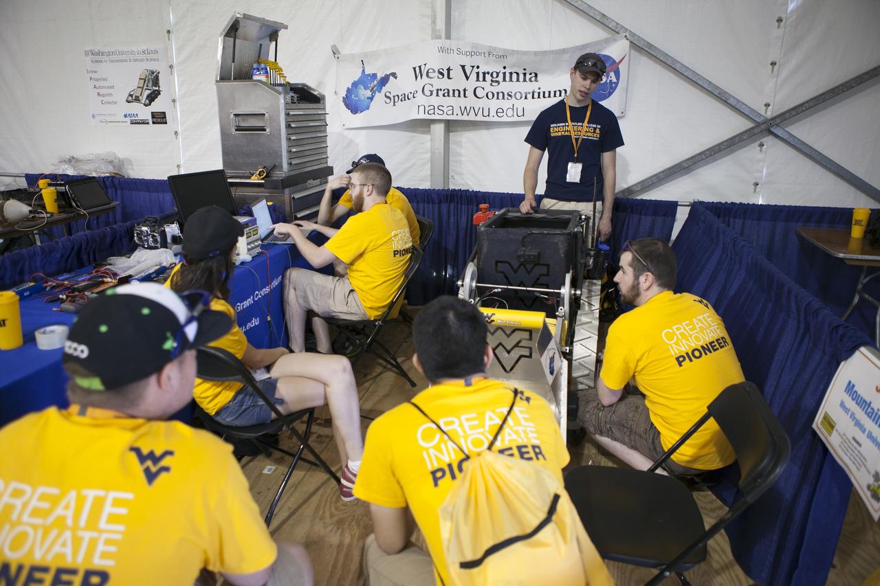 CAPE CANAVERAL, Fla. – Students from West Virginia University prepare their robot for NASA’s Robotics Mining Competition at the Kennedy Space Center Visitor Complex in Florida. More than 35 teams from around the U.S. have designed and built remote-controlled robots for the mining competition. The competition is a NASA Human Exploration and Operations Mission Directorate project designed to engage and retain students in science, technology, engineering and mathematics, or STEM, fields by expanding opportunities for student research and design. Teams use their remote-controlled robotics to maneuver and dig in a supersized sandbox filled with a crushed material that has characteristics similar to Martian soil. The objective of the challenge is to see which team’s robot can collect and move the most regolith within a specified amount of time. For more information, visit www.nasa.gov/nasarmc. Photo credit: NASA/Ben Smegelsky