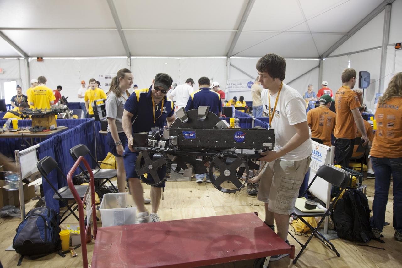 CAPE CANAVERAL, Fla. – College students prepare their robot for a trial run at NASA’s Robotics Mining Competition at the Kennedy Space Center Visitor Complex in Florida. More than 35 teams from around the U.S. have designed and built remote-controlled robots for the mining competition. The competition is a NASA Human Exploration and Operations Mission Directorate project designed to engage and retain students in science, technology, engineering and mathematics, or STEM, fields by expanding opportunities for student research and design. Teams use their remote-controlled robotics to maneuver and dig in a supersized sandbox filled with a crushed material that has characteristics similar to Martian soil. The objective of the challenge is to see which team’s robot can collect and move the most regolith within a specified amount of time. For more information, visit www.nasa.gov/nasarmc. Photo credit: NASA/Ben Smegelsky