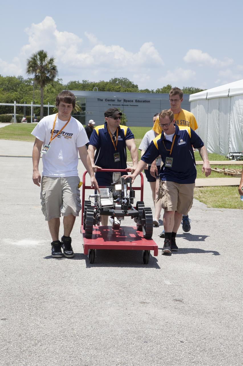 CAPE CANAVERAL, Fla. – College students from Montana State University prepare their robot for a trial run at NASA’s Robotics Mining Competition at the Kennedy Space Center Visitor Complex in Florida. More than 35 teams from around the U.S. have designed and built remote-controlled robots for the mining competition. The competition is a NASA Human Exploration and Operations Mission Directorate project designed to engage and retain students in science, technology, engineering and mathematics, or STEM, fields by expanding opportunities for student research and design. Teams use their remote-controlled robotics to maneuver and dig in a supersized sandbox filled with a crushed material that has characteristics similar to Martian soil. The objective of the challenge is to see which team’s robot can collect and move the most regolith within a specified amount of time. For more information, visit www.nasa.gov/nasarmc. Photo credit: NASA/Ben Smegelsky