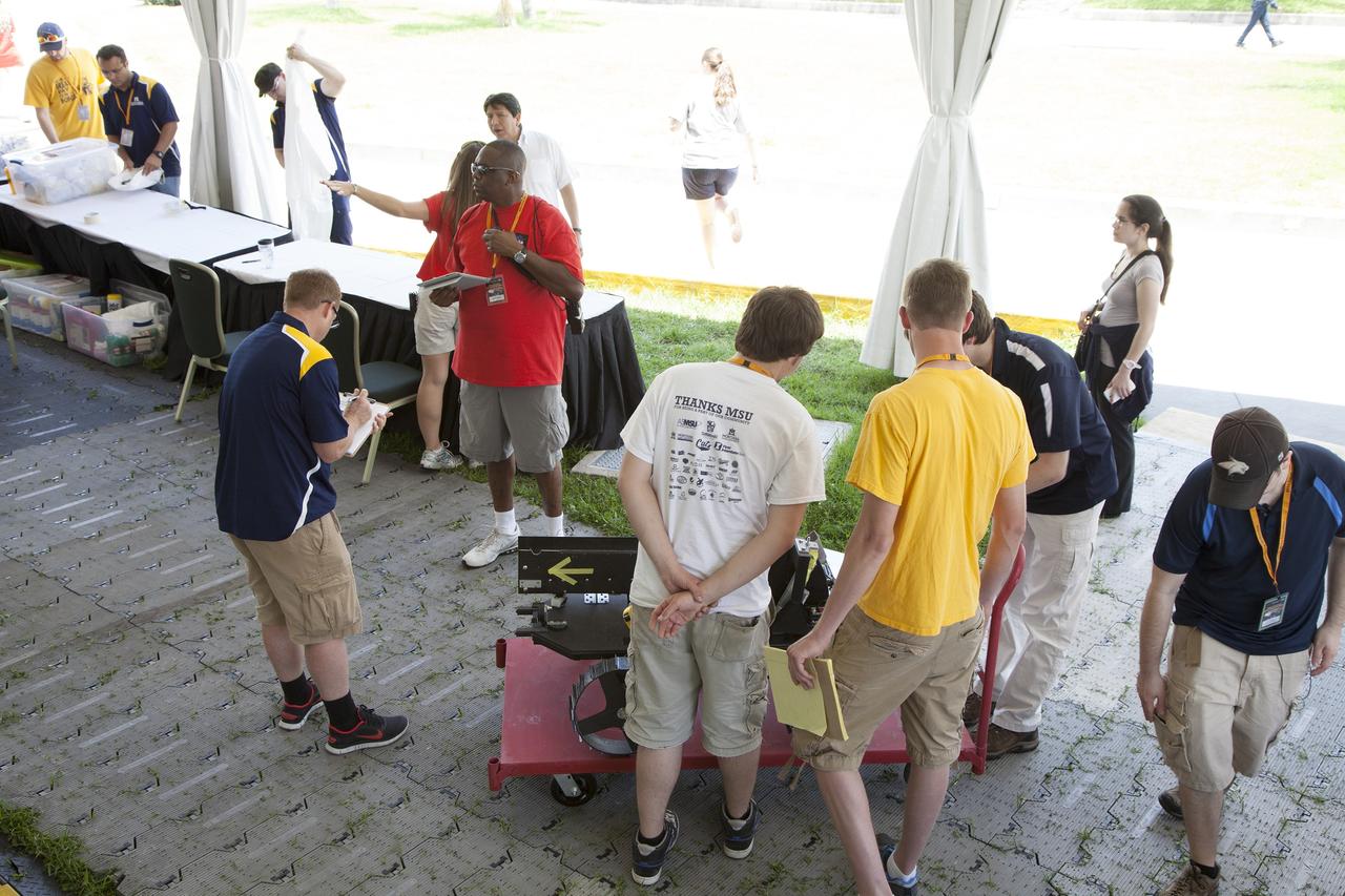 CAPE CANAVERAL, Fla. – College students from Montana State University prepare their robot for a trial run at NASA’s Robotics Mining Competition at the Kennedy Space Center Visitor Complex in Florida. More than 35 teams from around the U.S. have designed and built remote-controlled robots for the mining competition. The competition is a NASA Human Exploration and Operations Mission Directorate project designed to engage and retain students in science, technology, engineering and mathematics, or STEM, fields by expanding opportunities for student research and design. Teams use their remote-controlled robotics to maneuver and dig in a supersized sandbox filled with a crushed material that has characteristics similar to Martian soil. The objective of the challenge is to see which team’s robot can collect and move the most regolith within a specified amount of time. For more information, visit www.nasa.gov/nasarmc. Photo credit: NASA/Ben Smegelsky