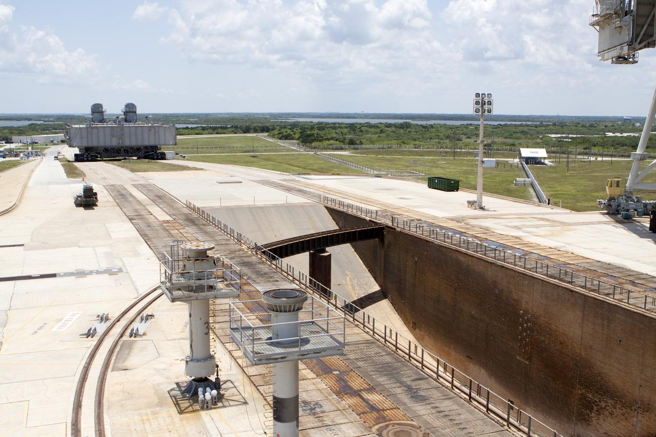 CAPE CANAVERAL, Fla. -- The flame trench comes into view on Launch Pad 39A as a crawler-transporter hauls Mobile Launcher Platform-2, or MLP-2, off the pad at NASA's Kennedy Space Center in Florida. The MLP is being moved to a nearby park site in Launch Complex 39.      The historic launch pad was the site from which numerous Apollo and space shuttle missions began and is beginning a new mission as a commercial launch site. NASA signed a property agreement with Space Exploration Technologies Corp., or SpaceX, of Hawthorne, California, on April 14 for use and occupancy of the seaside complex along Florida's central east coast. It will serve as a platform for SpaceX to support their commercial launch activities.  For more information on Launch Pad 39A, visit http://www.nasa.gov/centers/kennedy/pdf/167416main_LC39-08.pdf. For learn more about the crawler-transporter, visit http://www.nasa.gov/centers/kennedy/pdf/167402main_crawlertransporters07.pdf. Photo credit: NASA/Kim Shiflett