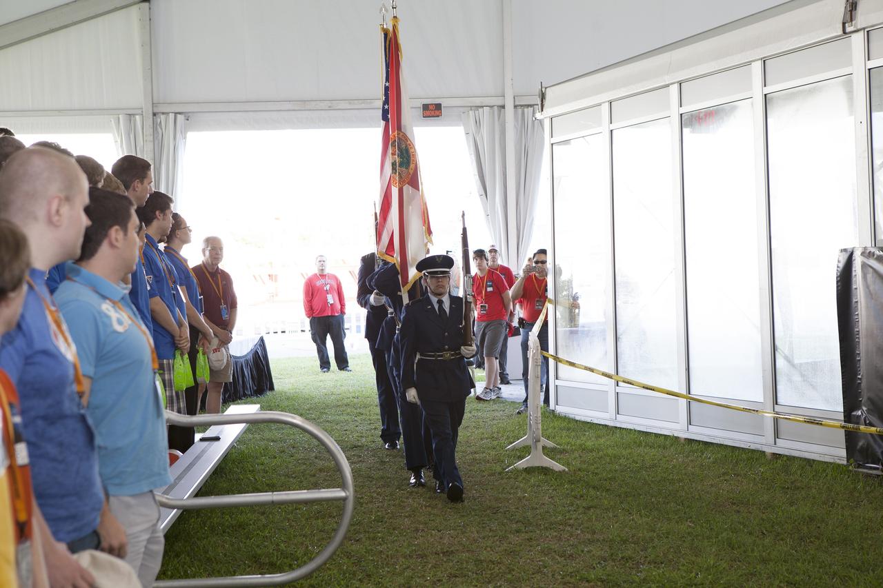 CAPE CANAVERAL, Fla. – Members of the West Virginia University color guard present the U.S. Flag during the opening ceremony of NASA’s 2014 Robotics Mining Competition at the Kennedy Space Center Visitor Complex in Florida. More than 35 teams from around the U.S. have designed and built remote-controlled robots for the mining competition.    The competition is a NASA Human Exploration and Operations Mission Directorate project designed to engage and retain students in science, technology, engineering and mathematics, or STEM, fields by expanding opportunities for student research and design. Teams use their remote-controlled robotics to maneuver and dig in a supersized sandbox filled with a crushed material that has characteristics similar to Martian soil. The objective of the challenge is to see which team’s robot can collect and move the most regolith within a specified amount of time. For more information, visit www.nasa.gov/nasarmc. Photo credit: NASA/Frankie Martin