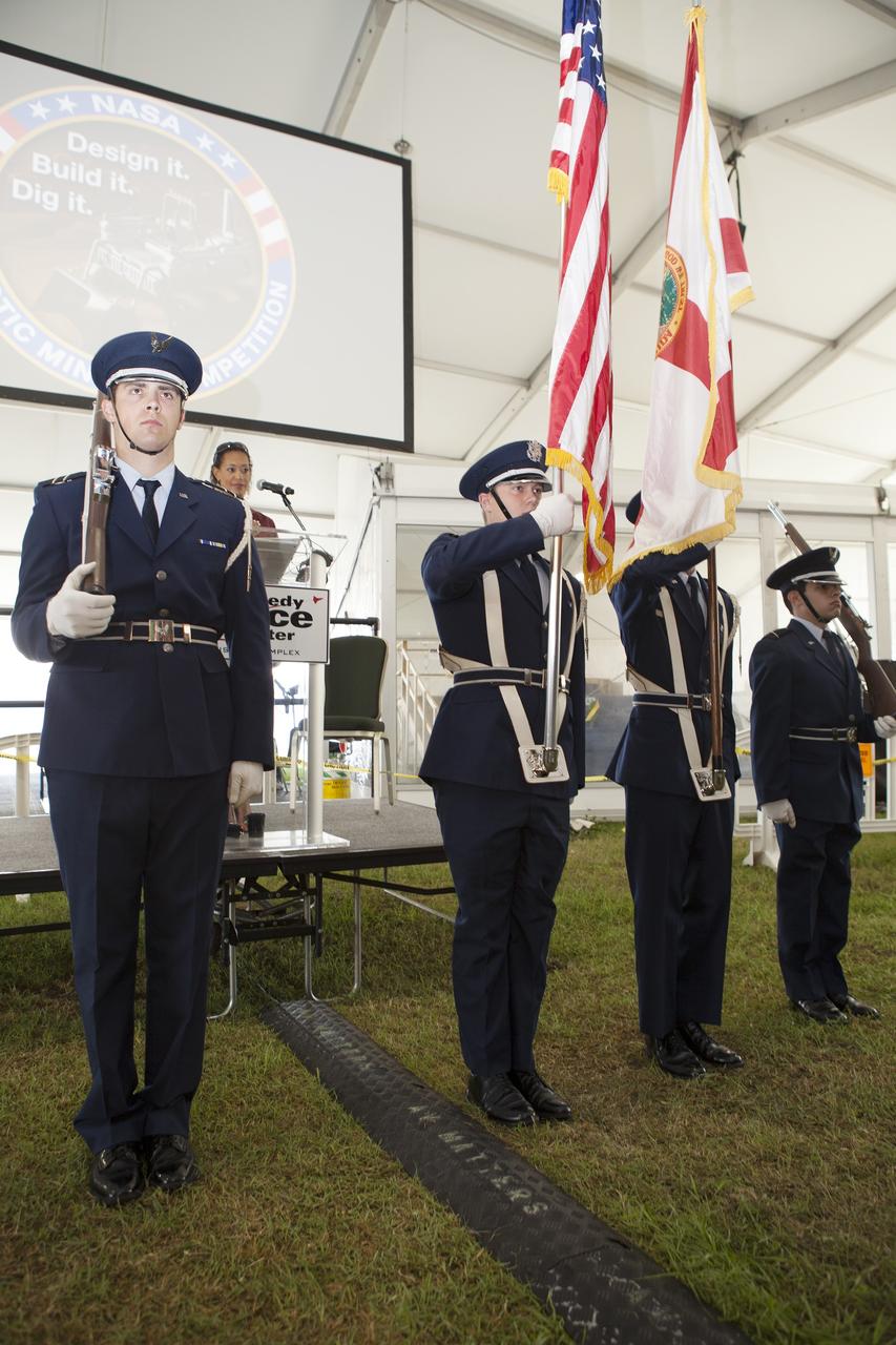 CAPE CANAVERAL, Fla. – Members of the West Virginia University color guard stand at attention during presentation of the U.S. Flag at the opening ceremony of NASA’s 2014 Robotics Mining Competition at the Kennedy Space Center Visitor Complex in Florida. More than 35 teams from around the U.S. have designed and built remote-controlled robots for the mining competition.     The competition is a NASA Human Exploration and Operations Mission Directorate project designed to engage and retain students in science, technology, engineering and mathematics, or STEM, fields by expanding opportunities for student research and design. Teams use their remote-controlled robotics to maneuver and dig in a supersized sandbox filled with a crushed material that has characteristics similar to Martian soil. The objective of the challenge is to see which team’s robot can collect and move the most regolith within a specified amount of time. For more information, visit www.nasa.gov/nasarmc. Photo credit: NASA/Frankie Martin