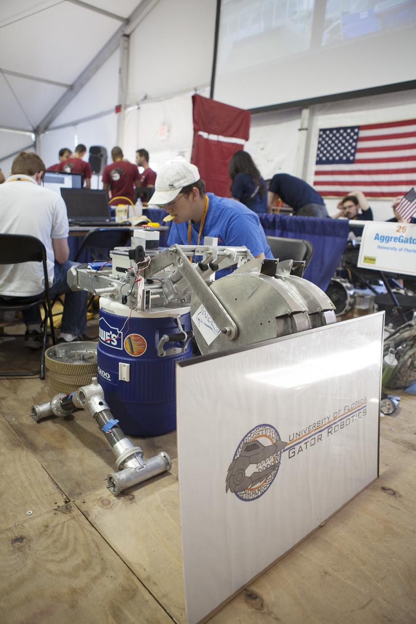 CAPE CANAVERAL, Fla. – Team members from the University of Florida in Gainesville prepare their robot for the mining portion of NASA's 2014 Robotics Mining Competition at the Kennedy Space Center Visitor Complex in Florida. More than 35 teams from around the U.S. have designed and built remote-controlled robots for the mining competition. The competition is a NASA Human Exploration and Operations Mission Directorate project designed to engage and retain students in science, technology, engineering and mathematics, or STEM, fields by expanding opportunities for student research and design. Teams use their remote-controlled robotics to maneuver and dig in a supersized sandbox filled with a crushed material that has characteristics similar to Martian soil. The objective of the challenge is to see which team’s robot can collect and move the most regolith within a specified amount of time. For more information, visit www.nasa.gov/nasarmc. Photo credit: NASA/Frankie Martin