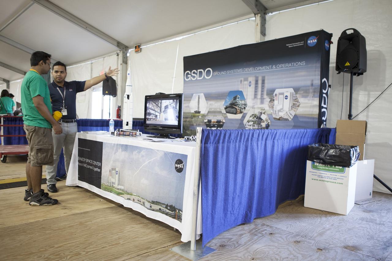 CAPE CANAVERAL, Fla. – A mining competition participant talks with a representative at the Ground Systems Development and Operations booth during NASA’s 2014 Robotic Mining Competition at the Kennedy Space Center Visitor Complex in Florida. More than 35 teams from colleges and universities around the U.S. have designed and built remote-controlled robots for the mining competition. The competition is a NASA Human Exploration and Operations Mission Directorate project designed to engage and retain students in science, technology, engineering and mathematics, or STEM, fields by expanding opportunities for student research and design. Teams use their remote-controlled robotics to maneuver and dig in a supersized sandbox filled with a crushed material that has characteristics similar to Martian soil. The objective of the challenge is to see which team’s robot can collect and move the most regolith within a specified amount of time. For more information, visit www.nasa.gov/nasarmc. Photo credit: NASA/Kim Shiflett