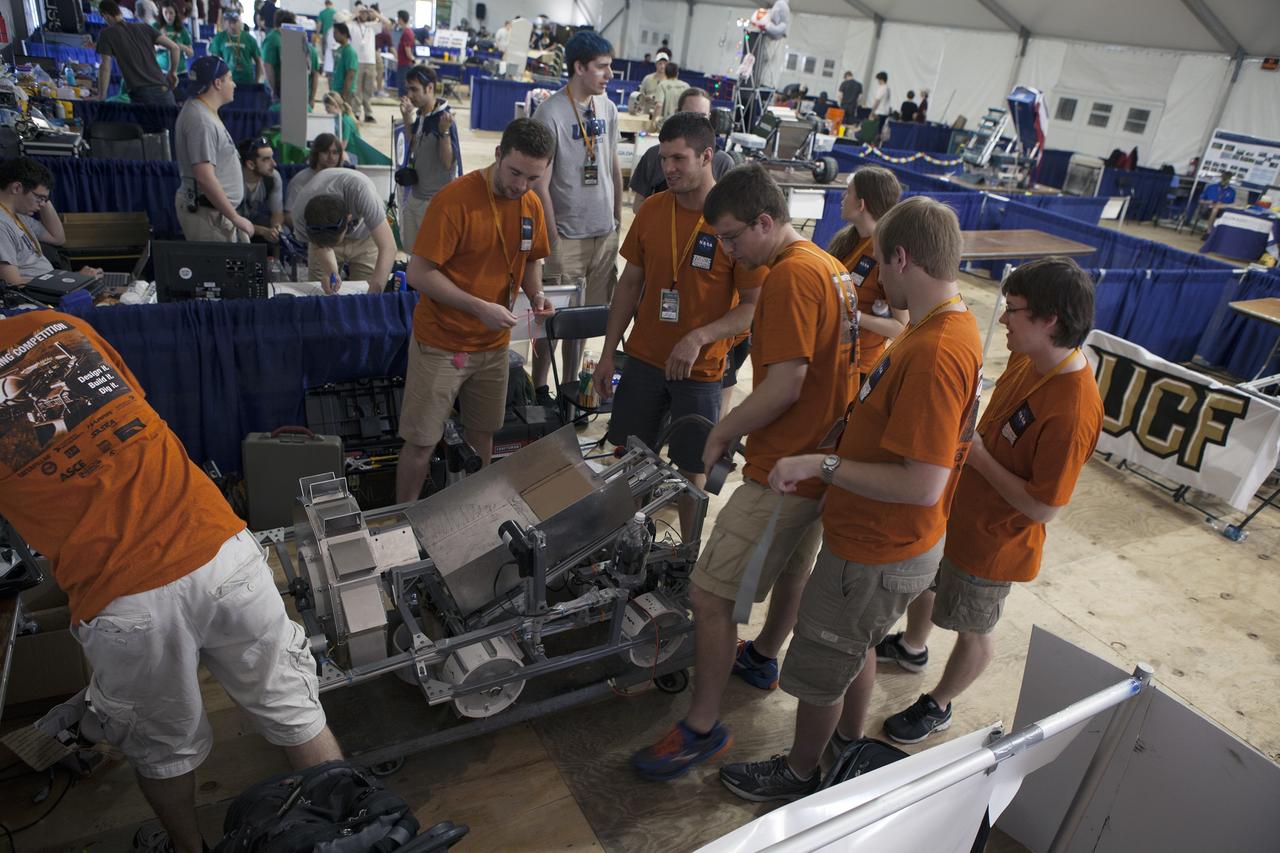 CAPE CANAVERAL, Fla. – College and university teams prepare their robots for the mining portion of NASA’s 2014 Robotic Mining Competition at the Kennedy Space Center Visitor Complex in Florida. More than 35 teams from around the U.S. have designed and built remote-controlled robots for the mining competition. The competition is a NASA Human Exploration and Operations Mission Directorate project designed to engage and retain students in science, technology, engineering and mathematics, or STEM, fields by expanding opportunities for student research and design. Teams use their remote-controlled robotics to maneuver and dig in a supersized sandbox filled with a crushed material that has characteristics similar to Martian soil. The objective of the challenge is to see which team’s robot can collect and move the most regolith within a specified amount of time. For more information, visit www.nasa.gov/nasarmc. Photo credit: NASA/Kim Shiflett