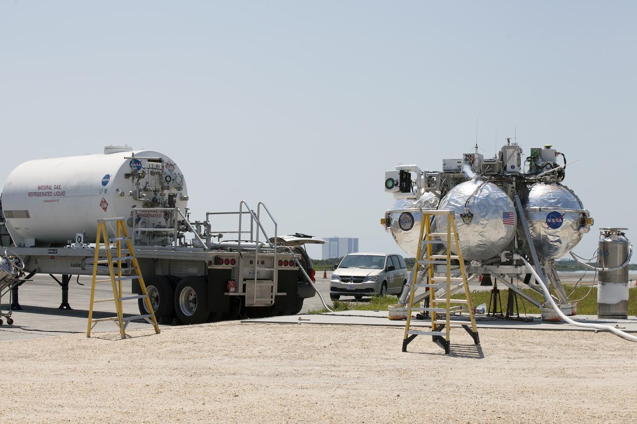 CAPE CANAVERAL, Fla. –NASA's Project Morpheus prototype lander is fueled prior to a free-flight test from a launch pad at the north end of the Shuttle Landing Facility at NASA’s Kennedy Space Center in Florida. Project Morpheus tests NASA’s ALHAT and an engine that runs on liquid oxygen and methane, which are green propellants. These new capabilities could be used in future efforts to deliver cargo to planetary surfaces. The landing facility provides the lander with the kind of field necessary for realistic testing, complete with rocks, craters and hazards to avoid. Morpheus’ ALHAT payload allows it to navigate to clear landing sites amidst rocks, craters and other hazards during its descent. Project Morpheus is being managed under the Advanced Exploration Systems, or AES, Division in NASA’s Human Exploration and Operations Mission Directorate. The efforts in AES pioneer new approaches for rapidly developing prototype systems, demonstrating key capabilities and validating operational concepts for future human missions beyond Earth orbit. For more information on Project Morpheus, visit http://morpheuslander.jsc.nasa.gov/. Photo credit: NASA/Kim Shiflett