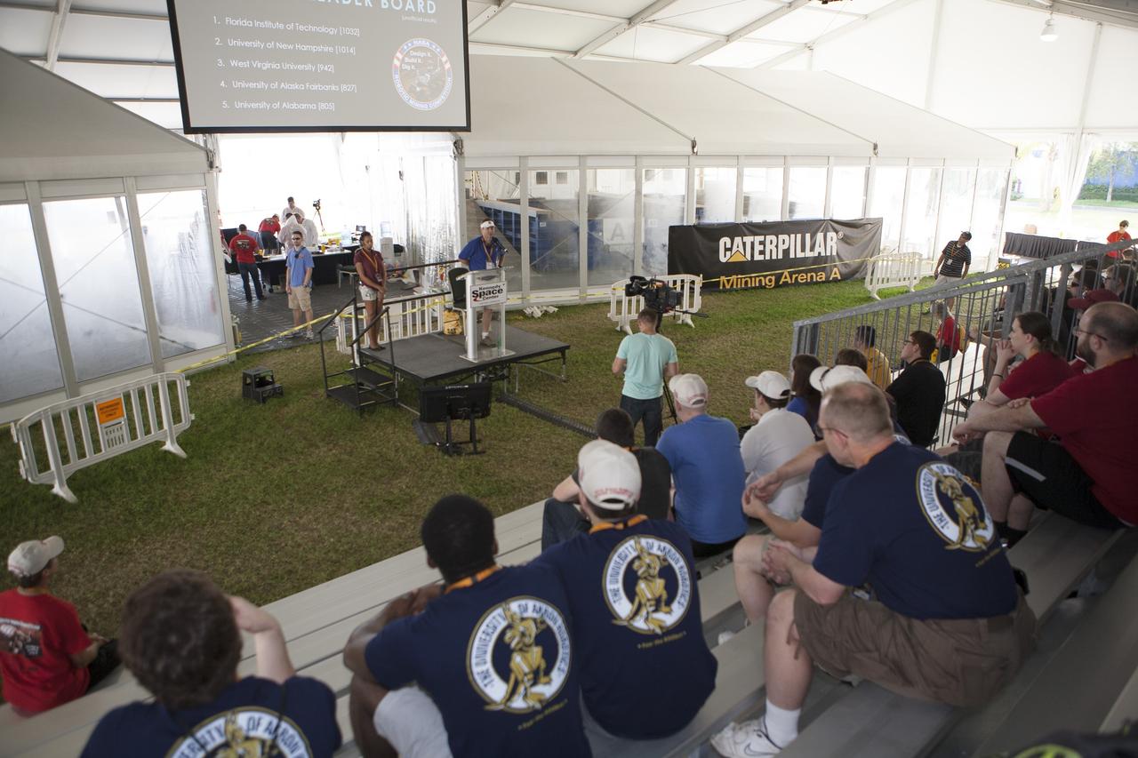 CAPE CANAVERAL, Fla. – Rob Mueller, lead technical expert and head judge from Kennedy Space Center's Engineering and Technology Directorate, makes opening remarks on the final day of NASA's 2014 Robotic Mining Competition at the Kennedy Space Center Visitor Complex in Florida. More than 35 teams from colleges and universities around the U.S. designed and built remote-controlled robots for the mining competition. The competition is a NASA Human Exploration and Operations Mission Directorate project designed to engage and retain students in science, technology, engineering and mathematics, or STEM, fields by expanding opportunities for student research and design. Teams use their remote-controlled robotics to maneuver and dig in a supersized sandbox filled with a crushed material that has characteristics similar to Martian soil. The objective of the challenge is to see which team’s robot can collect and move the most regolith within a specified amount of time. For more information, visit www.nasa.gov/nasarmc. Photo credit: NASA/Kim Shiflett