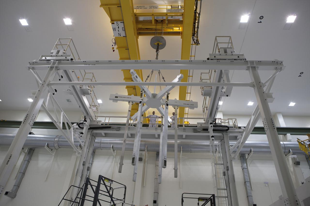 CAPE CANAVERAL, Fla. – Inside the Operations and Checkout Building high bay at NASA's Kennedy Space Center in Florida, a crane is being moved into position to lift the Orion crew module from a test stand. Activities are underway to prepare Orion for future installation of the heat shield.    Orion is the exploration spacecraft designed to carry astronauts to destinations not yet explored by humans, including an asteroid and Mars. It will have emergency abort capability, sustain the crew during space travel and provide safe re-entry from deep space return velocities. The first unpiloted test flight of the Orion is scheduled to launch in 2014 atop a Delta IV rocket and in 2017 on NASA’s Space Launch System rocket. For more information, visit http://www.nasa.gov/orion. Photo credit: NASA/Dimitri Gerondidakis