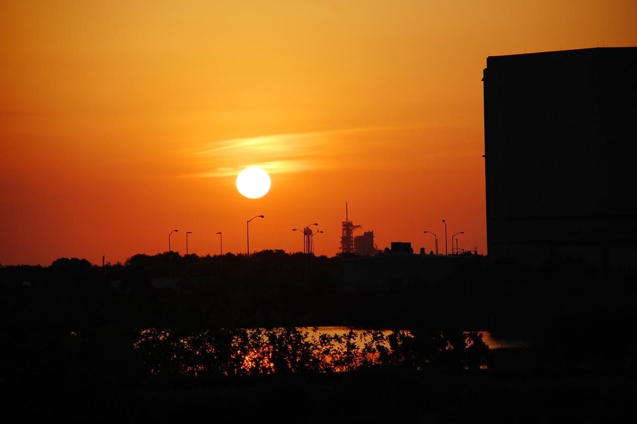 CAPE CANAVERAL, Fla. -- The sun rises over NASA's Kennedy Space Center in Florida. In view at right are Launch Pad 39A and the Rotation/Processing Facility, which supported solid rocket booster preparations during the Space Shuttle Program.      On this particular morning, preparations are underway for a launch from Space Launch Complex-41 on Cape Canaveral Air Force Station, a part of the spaceport which neighbors Kennedy Space Center.  For more information, visit http://www.nasa.gov/centers/kennedy.  Photo credit: NASA/Ben Smegelsky