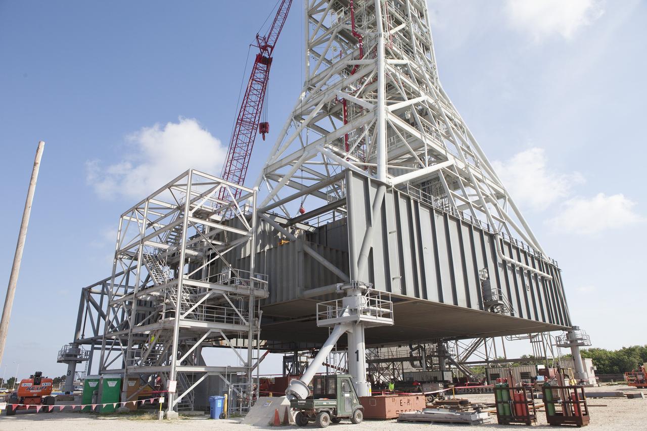 CAPE CANAVERAL, Fla. -- Modifications continue on the Mobile Launcher, or ML, at the Mobile Launcher Park Site at NASA’s Kennedy Space Center in Florida. Construction workers have welded sections of the steel walls. The ML is being modified and strengthened to accommodate the weight, size and thrust at launch of NASA's Space Launch System, or SLS, and Orion spacecraft.    In 2013, the agency awarded a contract to J.P. Donovan Construction Inc. of Rockledge, Fla., to modify the ML, which is one of the key elements of ground support equipment that is being upgraded by the Ground Systems Development and Operations Program office at Kennedy. The existing 24-foot exhaust hole is being enlarged and strengthened for the larger, heavier SLS rocket. The ML will carry the SLS rocket and Orion spacecraft to Launch Pad 39B for its first mission, Exploration Mission-1, in 2017. Photo credit: NASA/Daniel Casper
