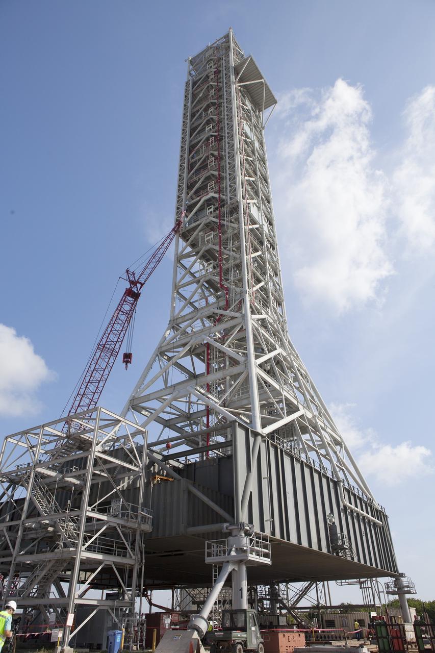 CAPE CANAVERAL, Fla. -- Modifications continue on the Mobile Launcher, or ML, at the Mobile Launcher Park Site at NASA’s Kennedy Space Center in Florida. Construction workers have welded sections of the steel walls. The ML is being modified and strengthened to accommodate the weight, size and thrust at launch of NASA's Space Launch System, or SLS, and Orion spacecraft.    In 2013, the agency awarded a contract to J.P. Donovan Construction Inc. of Rockledge, Fla., to modify the ML, which is one of the key elements of ground support equipment that is being upgraded by the Ground Systems Development and Operations Program office at Kennedy. The existing 24-foot exhaust hole is being enlarged and strengthened for the larger, heavier SLS rocket. The ML will carry the SLS rocket and Orion spacecraft to Launch Pad 39B for its first mission, Exploration Mission-1, in 2017. Photo credit: NASA/Daniel Casper