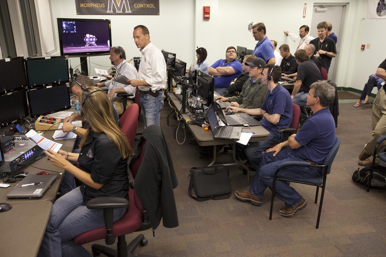 CAPE CANAVERAL, Fla. -- Engineers in the Morpheus Control Room monitor conditions in preparation for the first free flight test at night of NASA's Project Morpheus prototype lander from a launch pad at the north end of the Shuttle Landing Facility at NASA's Kennedy Space Center in Florida. The 98-second test began at 10:02 p.m. EDT with the Morpheus lander launching from the ground over a flame trench and ascending more than 800 feet. The vehicle, with its autonomous landing and hazard avoidance technology, or ALHAT sensors, surveyed the hazard field to determine safe landing sites. Morpheus then flew forward and downward covering approximately 1,300 feet while performing a 78-foot divert to simulate a hazard avoidance maneuver. The lander then descended and landed on a dedicated pad inside the test field. Project Morpheus tests NASA’s ALHAT and an engine that runs on liquid oxygen and methane, which are green propellants. These new capabilities could be used in future efforts to deliver cargo to planetary surfaces. The landing facility provides the lander with the kind of field necessary for realistic testing, complete with rocks, craters and hazards to avoid. Morpheus’ ALHAT payload allows it to navigate to clear landing sites amidst rocks, craters and other hazards during its descent. Project Morpheus is being managed under the Advanced Exploration Systems, or AES, Division in NASA’s Human Exploration and Operations Mission Directorate. The efforts in AES pioneer new approaches for rapidly developing prototype systems, demonstrating key capabilities and validating operational concepts for future human missions beyond Earth orbit. For more information on Project Morpheus, visit http://morpheuslander.jsc.nasa.gov/. Photo credit: NASA/Kim Shiflett